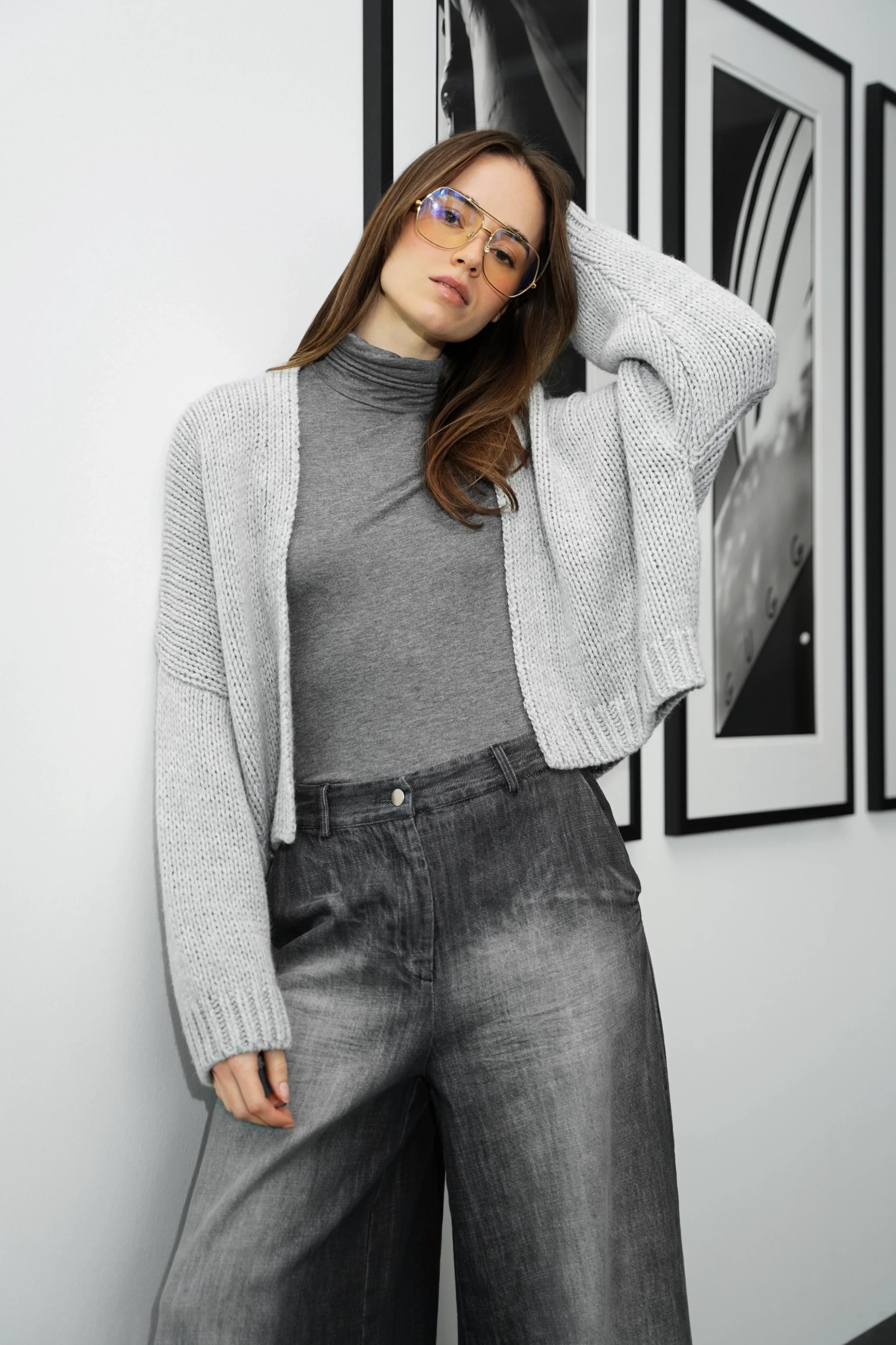 Woman wearing grey ALIXA Cropped Strickcardigan with loose fit and ribbed cuffs over a grey turtleneck and jeans indoors