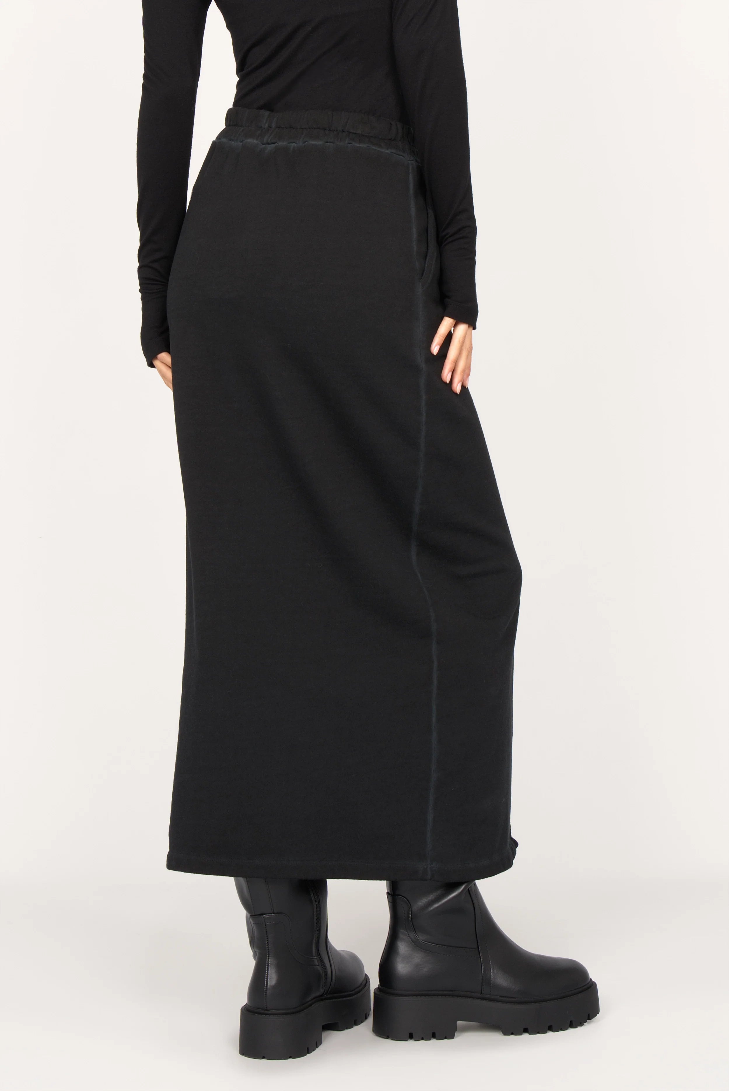Black ALEMENE Studio Sweatrock midi skirt with elastic waistband, side pockets, front slit, and cotton sweat material.