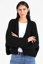 Frau trägt ALIXA Cropped Strickcardigan in Schwarz mit Oversize-Fit und Schalkragen aus weichem Woll-Mix