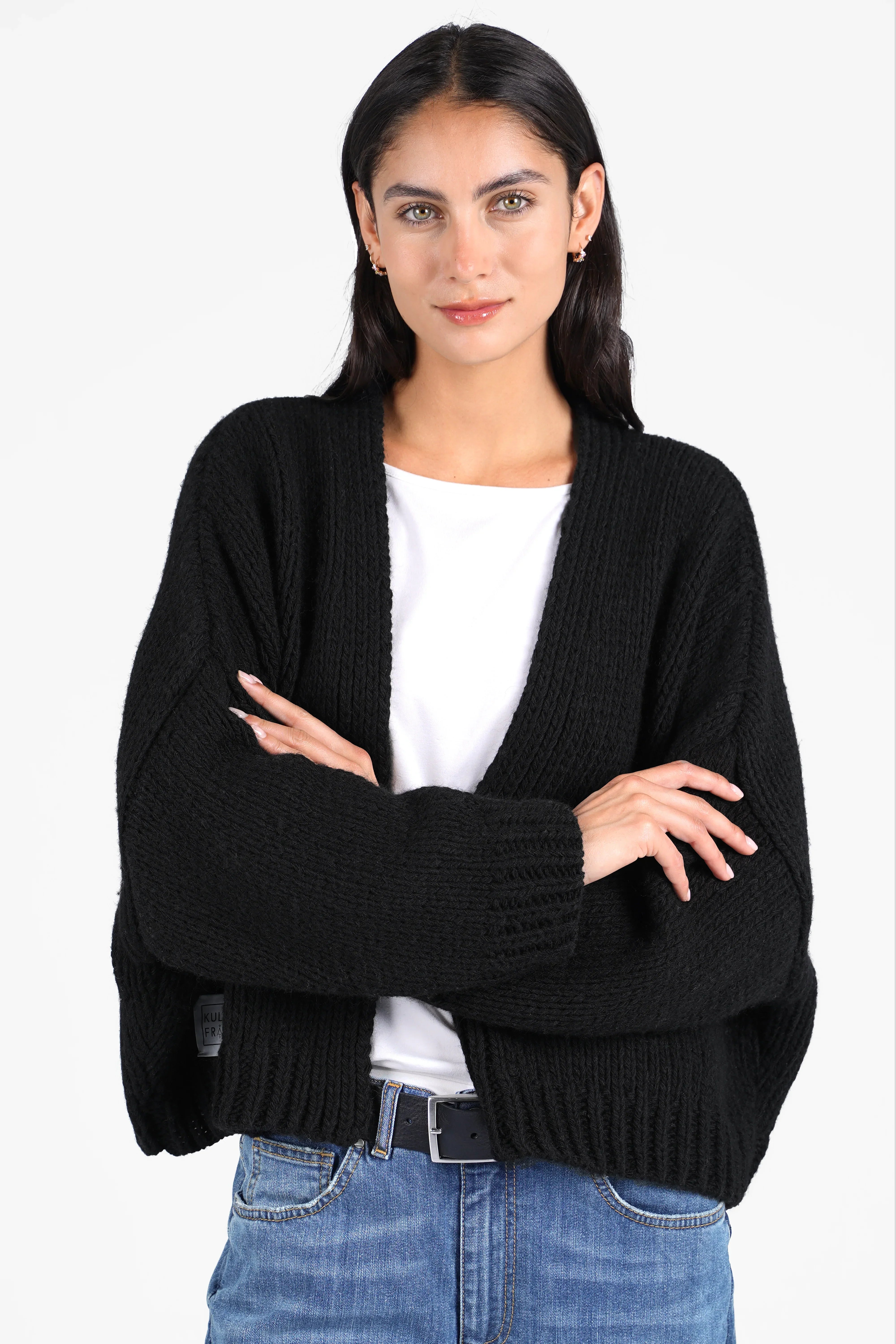 Frau trägt ALIXA Cropped Strickcardigan in Schwarz mit Oversize-Fit und Schalkragen aus weichem Woll-Mix