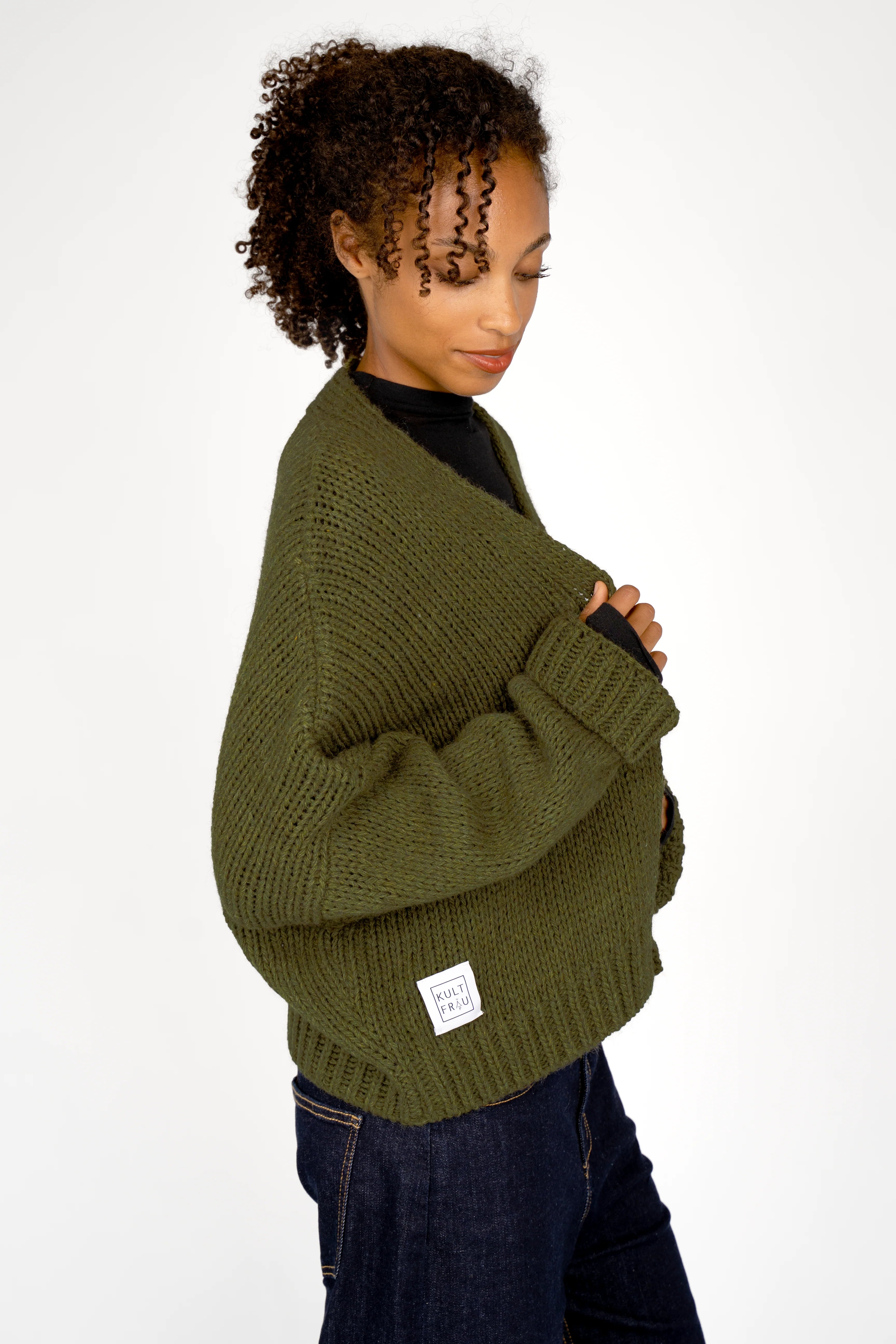 Damen trägt ALIXA Cropped Strickcardigan in Olivegrün mit lockerem Oversize-Fit und Schalkragen