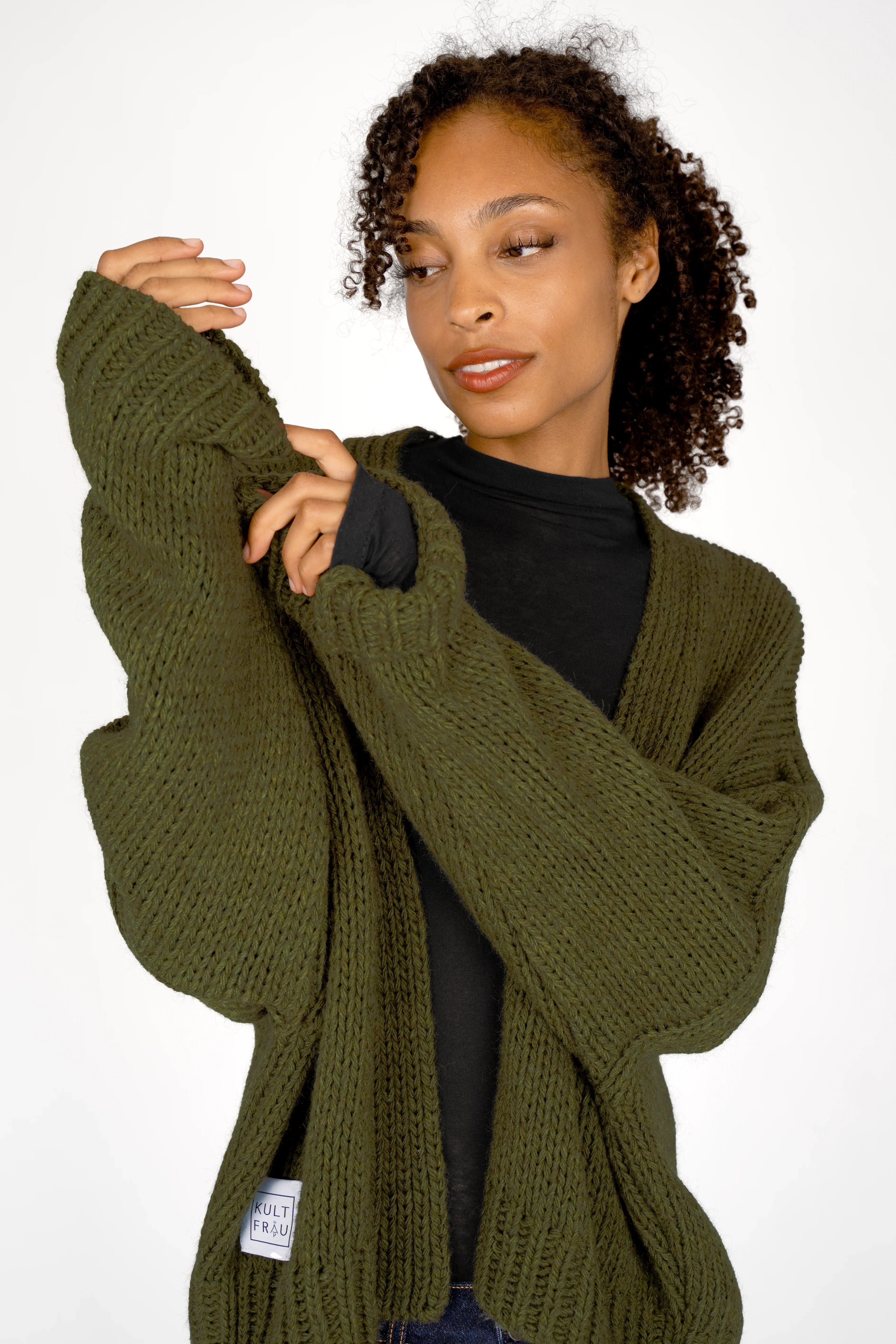 ALIXA Cropped Strickcardigan in olive green with loose fit and ribbed cuffs worn by woman