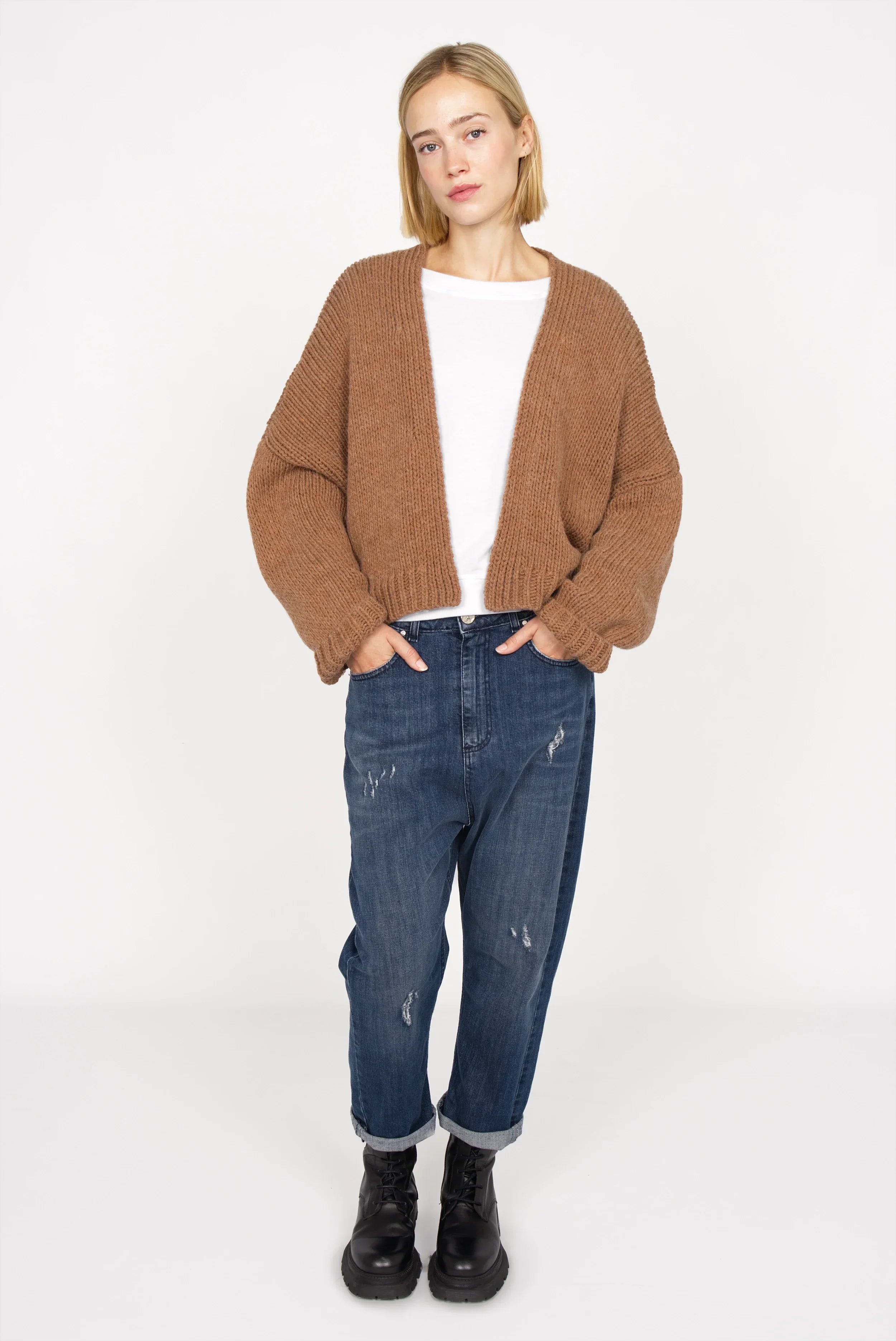 Woman wearing brown ALIXA Cropped Strickcardigan with loose fit and ribbed cuffs over white top and blue jeans