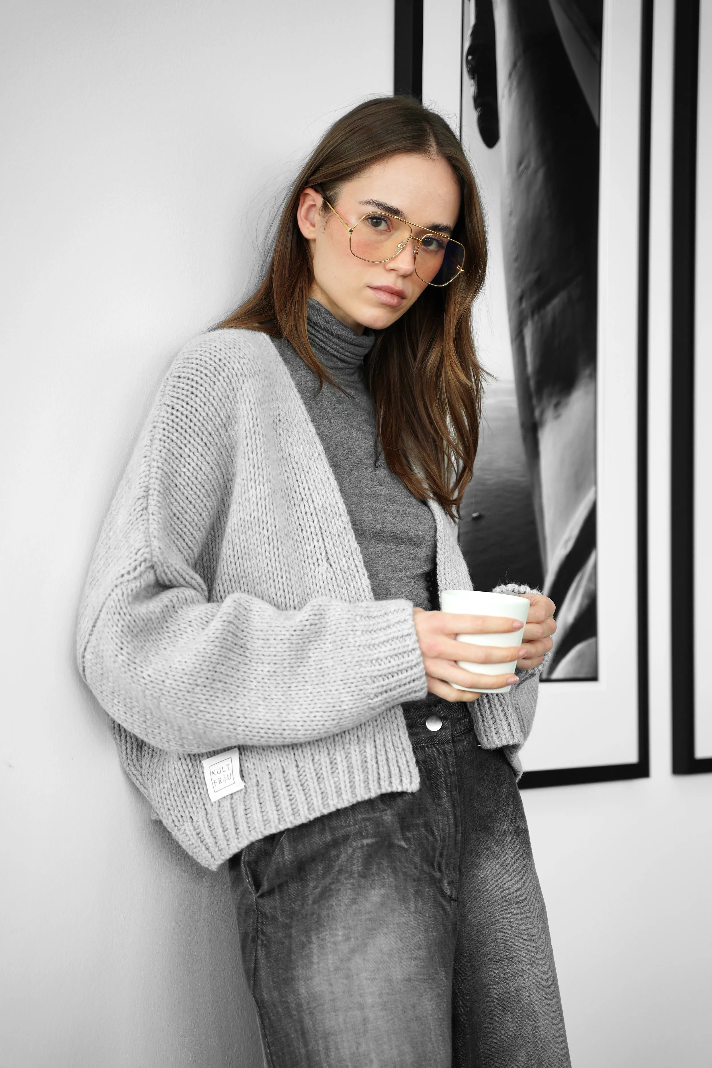 Frau trägt ALIXA Cropped Strickcardigan in Grau mit Schalkragen und oversized Passform