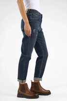 Dark blue boyfriend jeans with distressed details, mid waist, relaxed fit, and rolled cuffs.