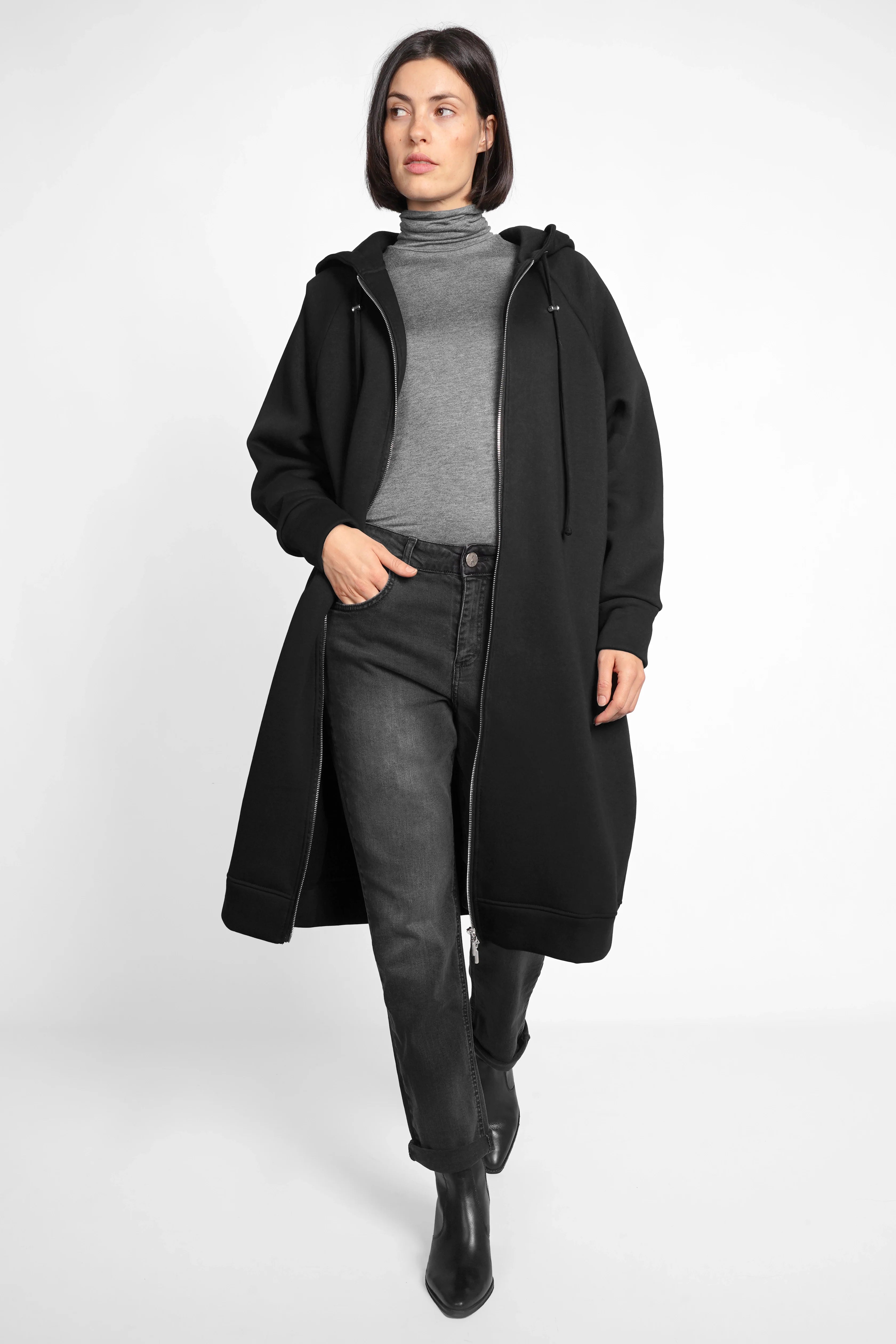 Faded black ALVA Boyfriend-Jeans in soft stretch denim with mid waist and tapered leg, styled casually with a long black coat and gray turtleneck.