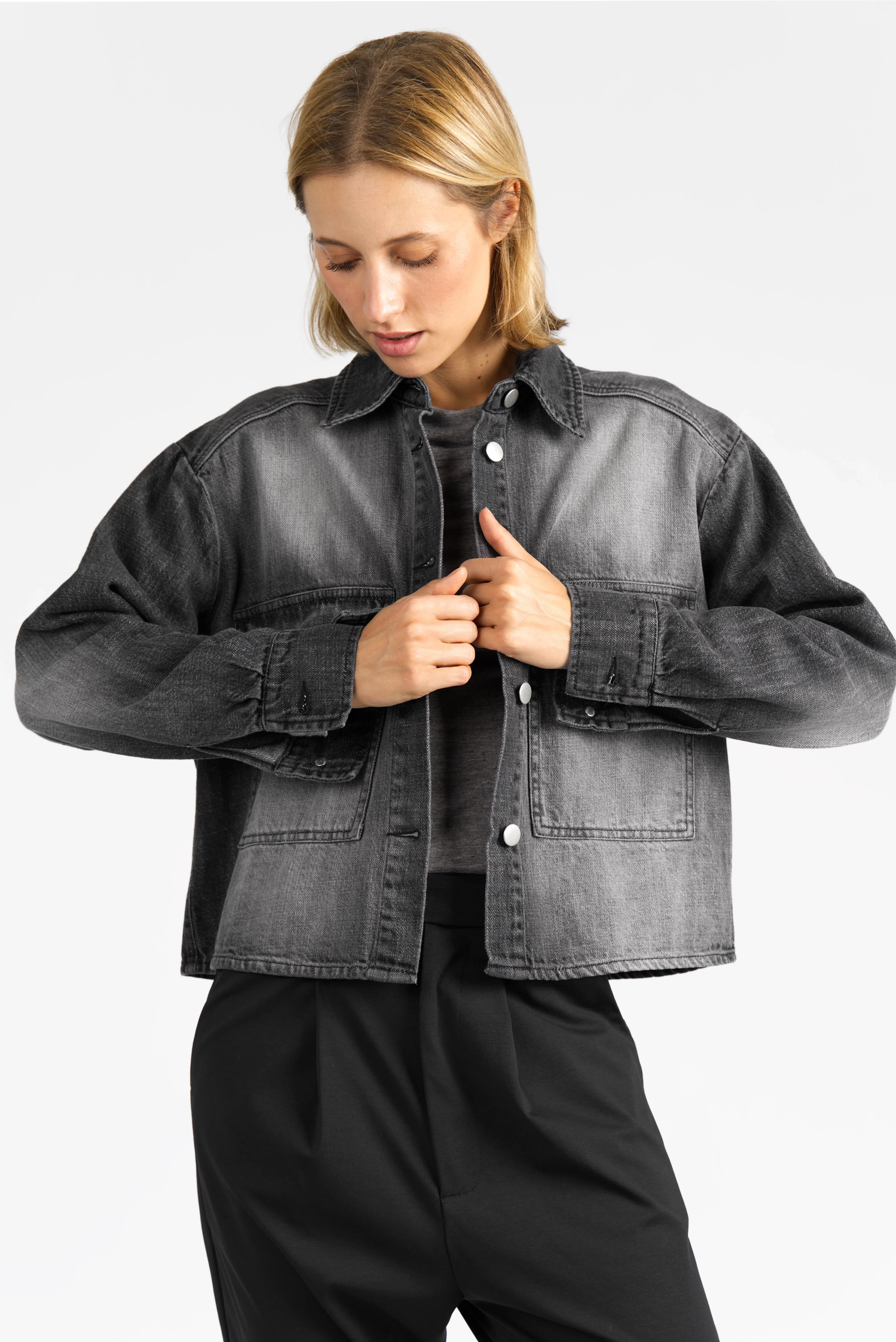 Frau trägt graue AMAKU Revive Hemdjacke mit klassischem Kragen und Brusttaschen in Regular Fit