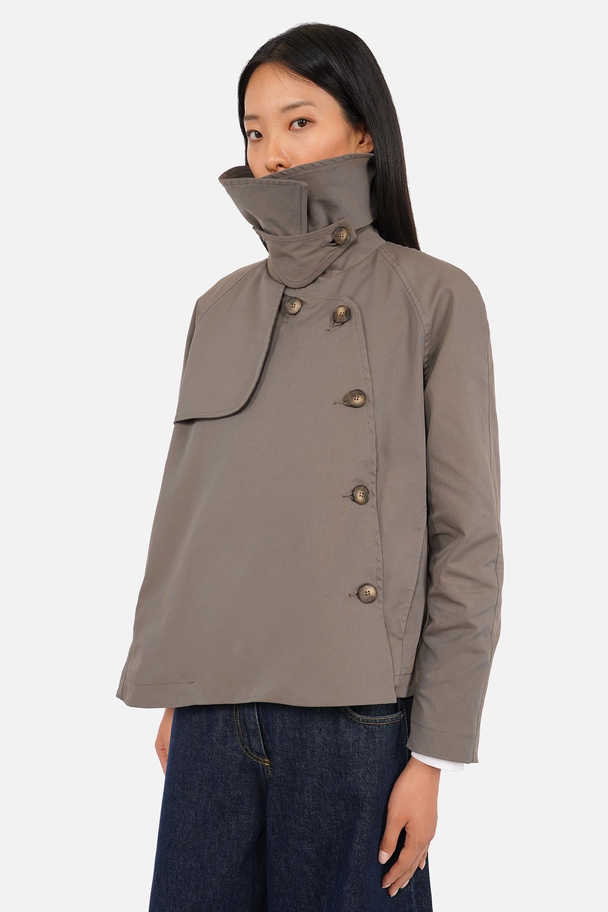 ANESA Trenchjacke mit Statement-Kragen aus technischem Twillstoff, asymmetrischem Design und seitlicher Knopfführung.