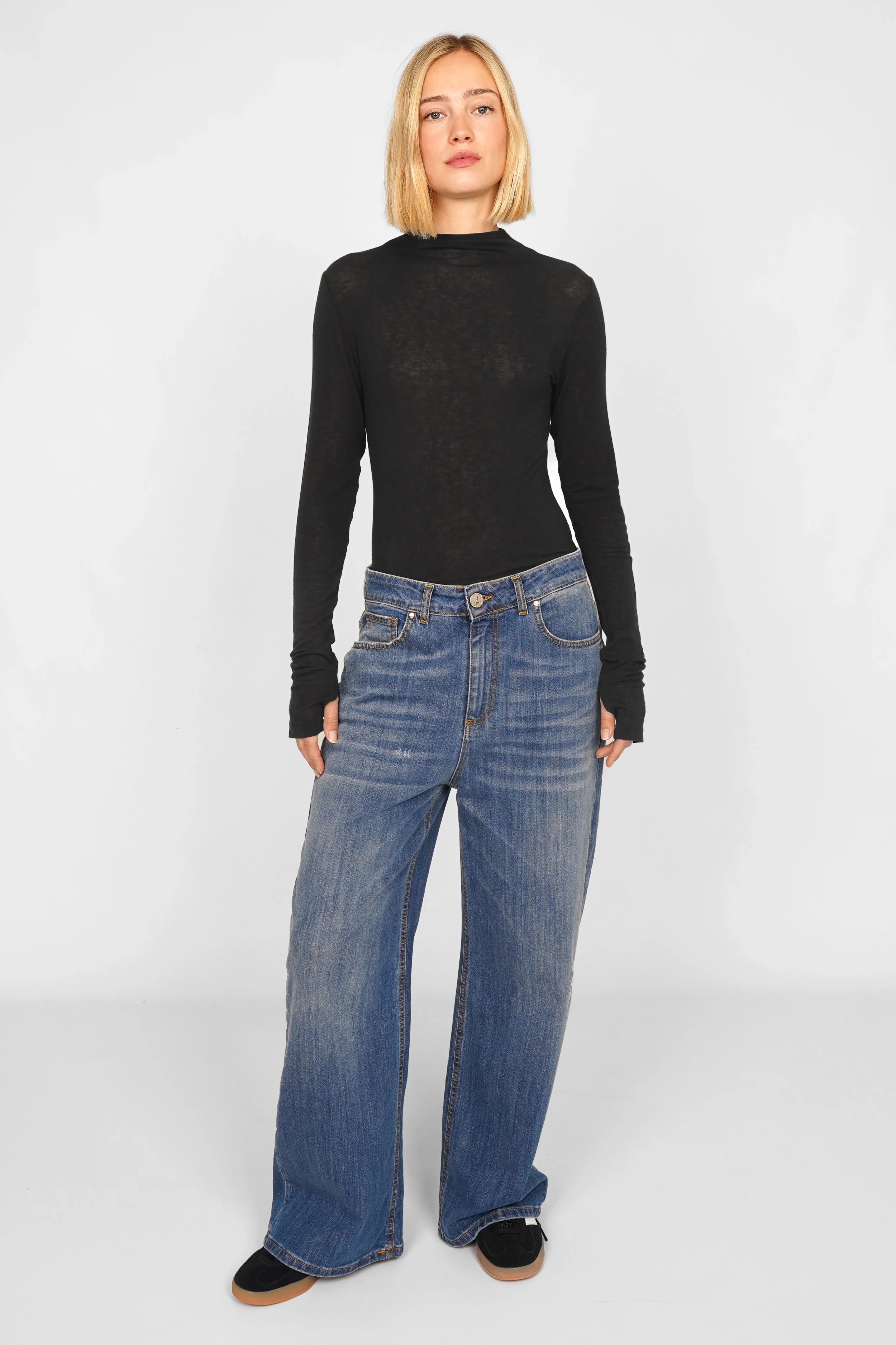 Frau trägt schwarzes Longsleeve aus Kaschmirmix mit Daumenlöchern und schmaler Passform