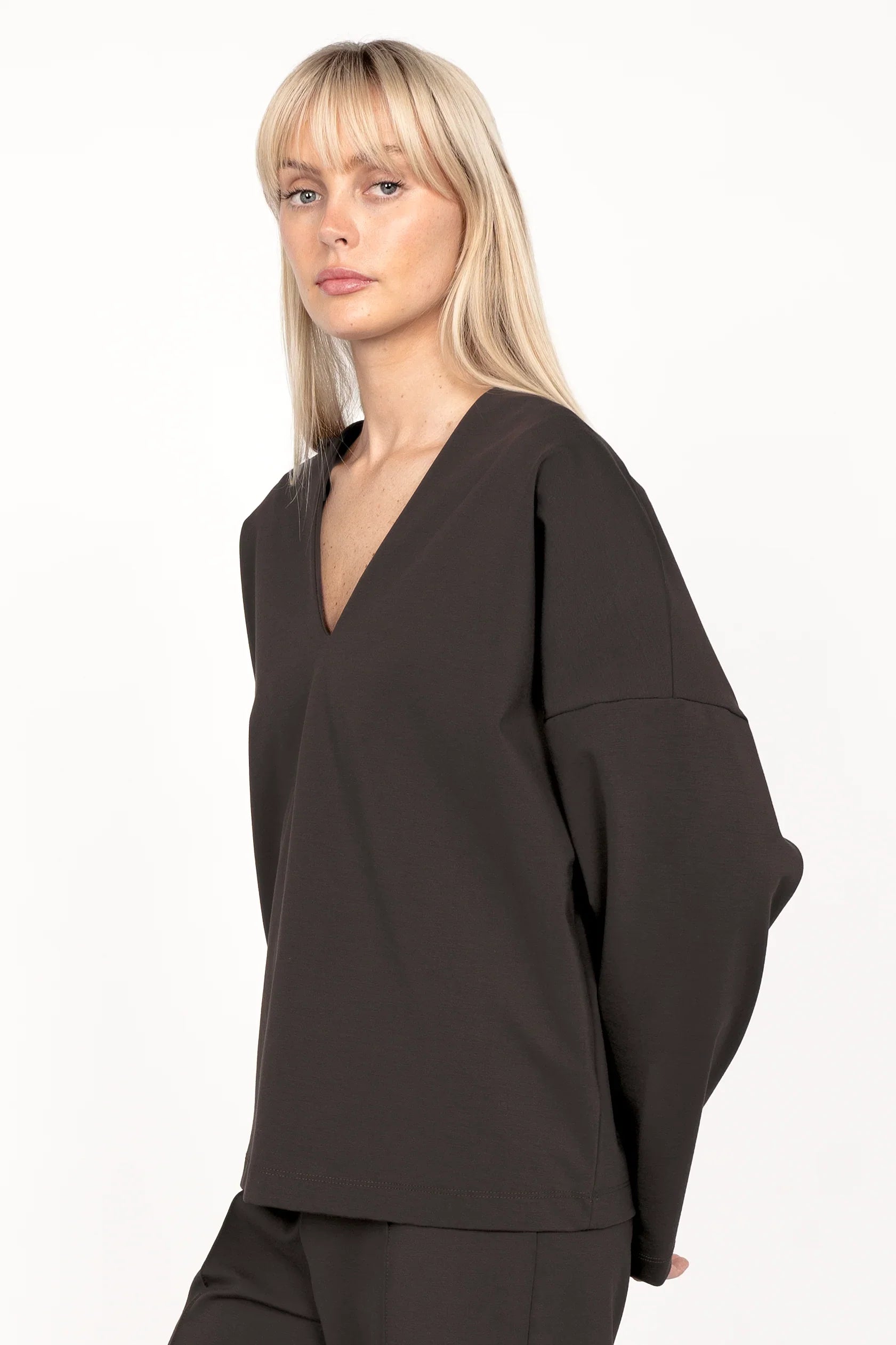 Woman wearing black BERLEY Relaxed V-Neck Bluse with relaxed fit and dropped shoulders