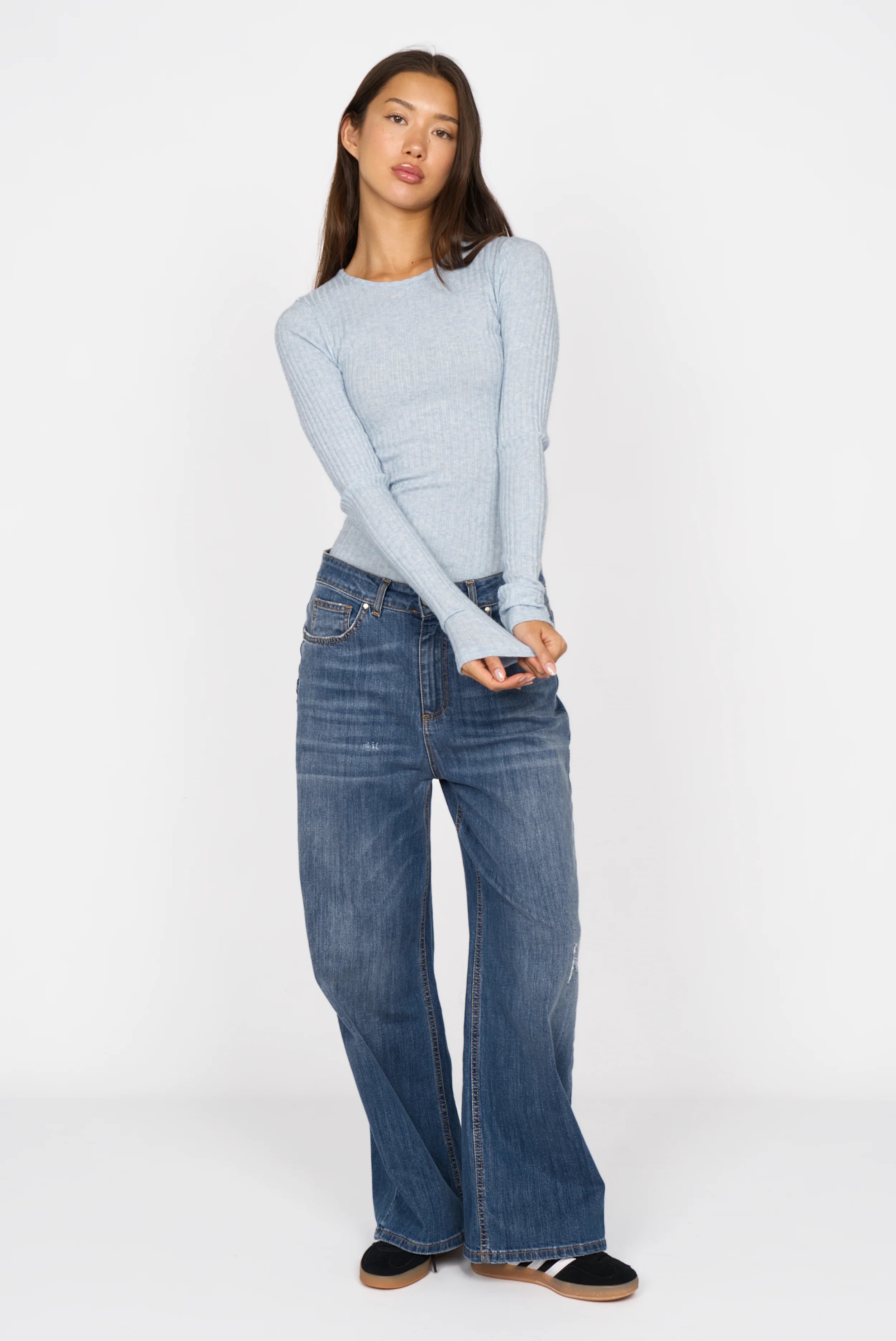 Slim fit BETTIE Longsleeve in soft light blue ribbed viscose blend with round neckline and extra long sleeves worn with wide-leg jeans.