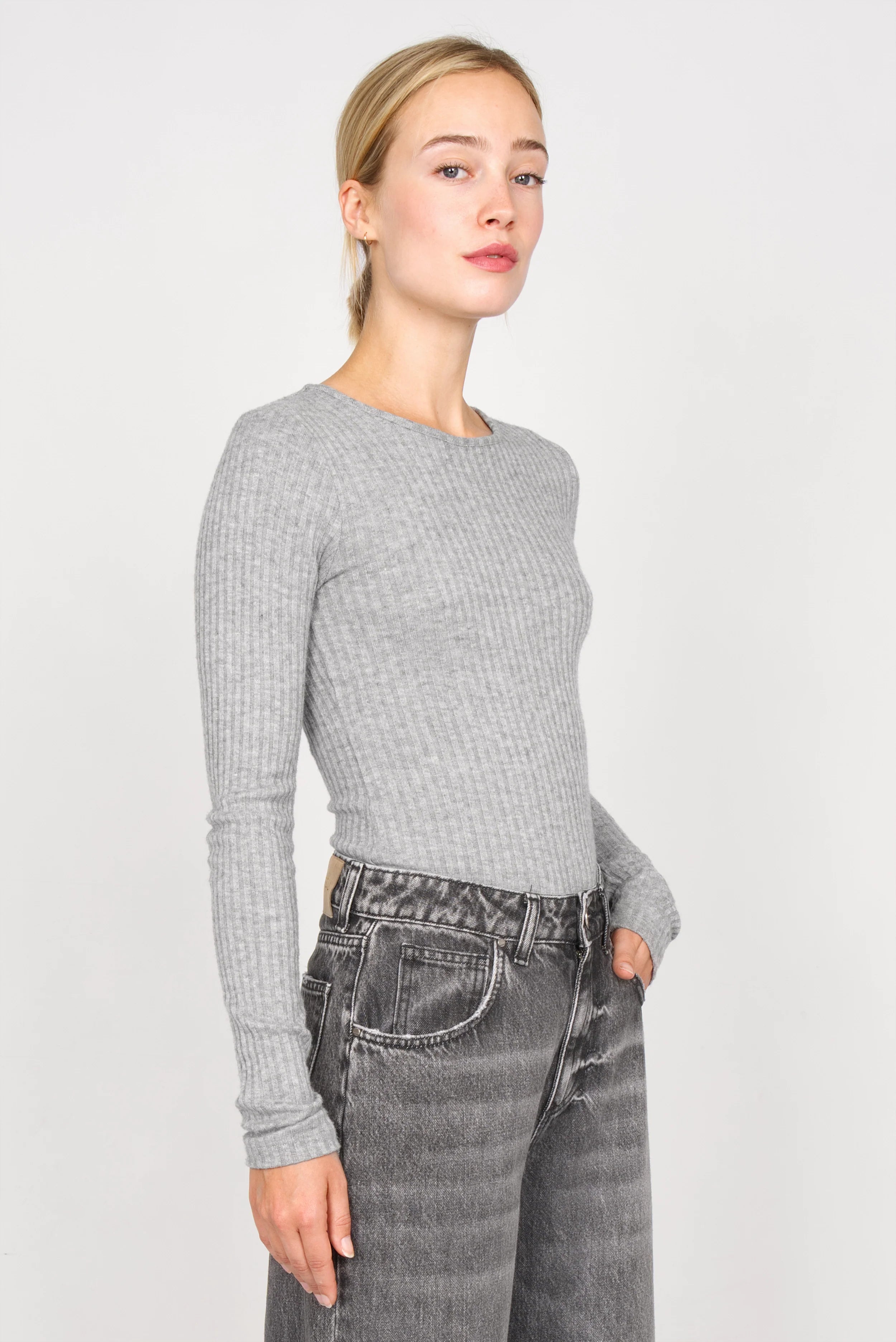 Frau trägt graues BETTIE Longsleeve aus feinem Rippstrick mit extra langen Ärmeln und slim Fit