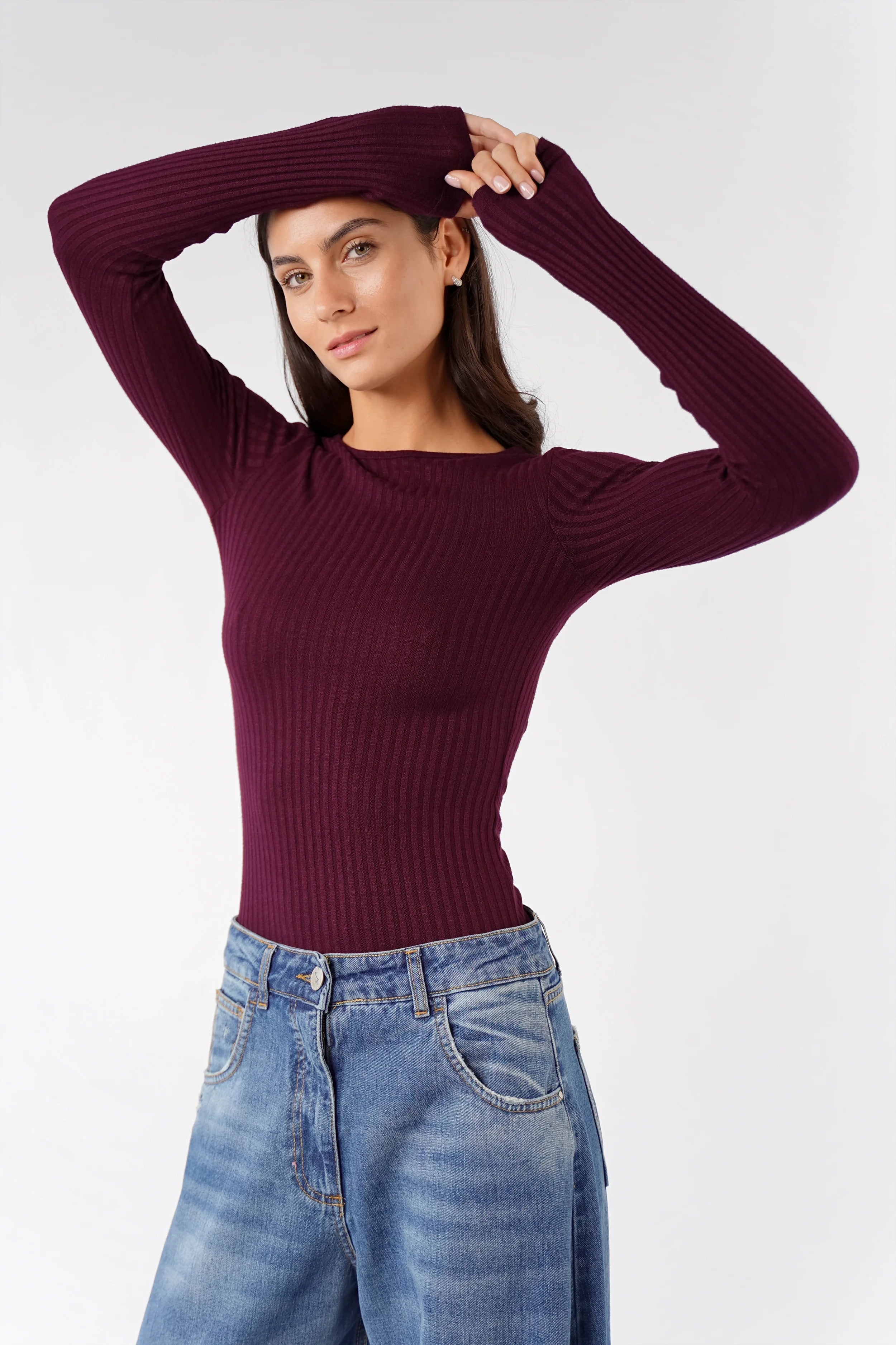 Femme portant un longsleeve Bettie en fine maille côtelée bordeaux slim fit avec manches longues et col rond.