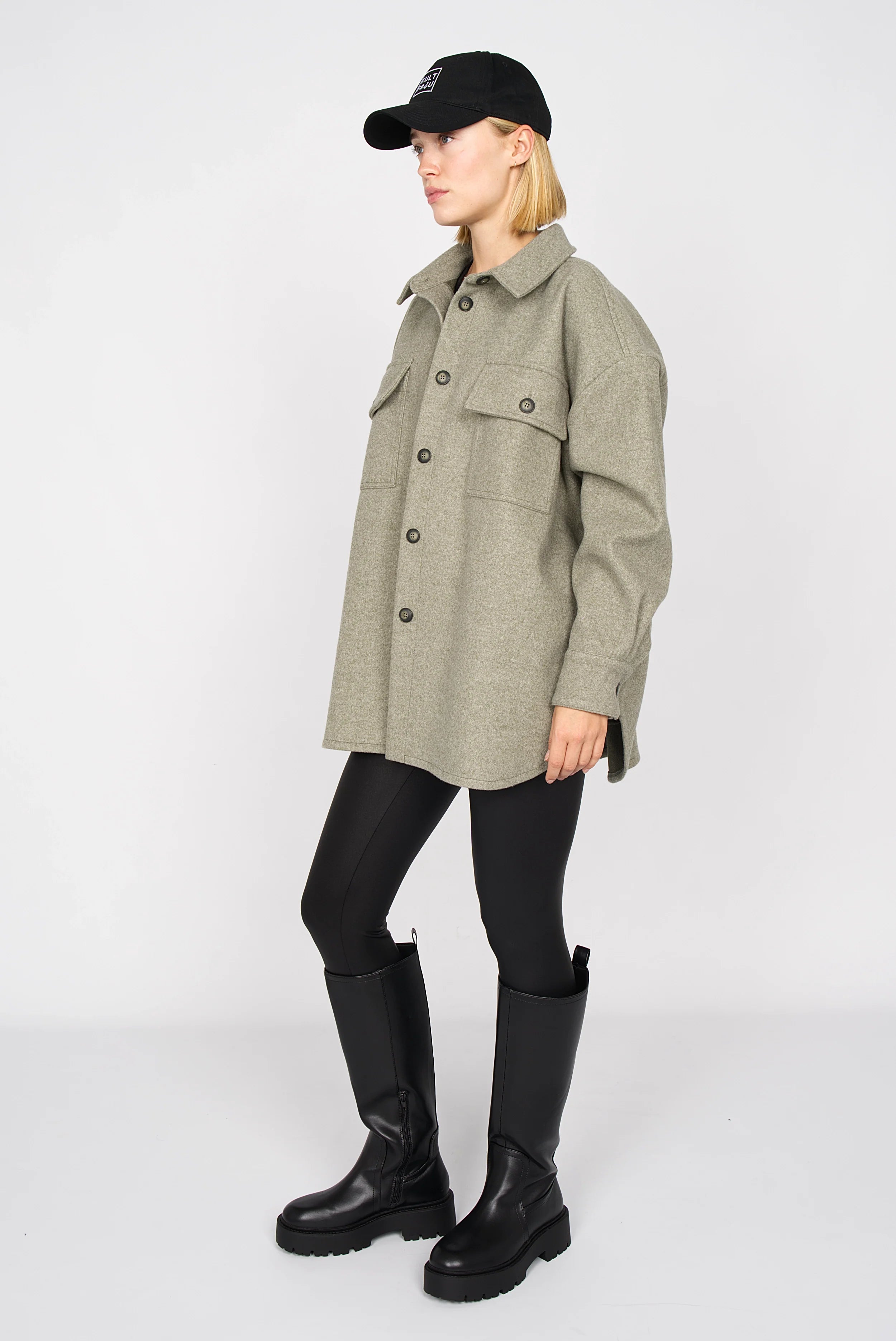 BJORA Overshirt aus festem Wollmix mit Brusttaschen und oversized Passform, getragen von Model mit schwarzer Mütze und Stiefeln.