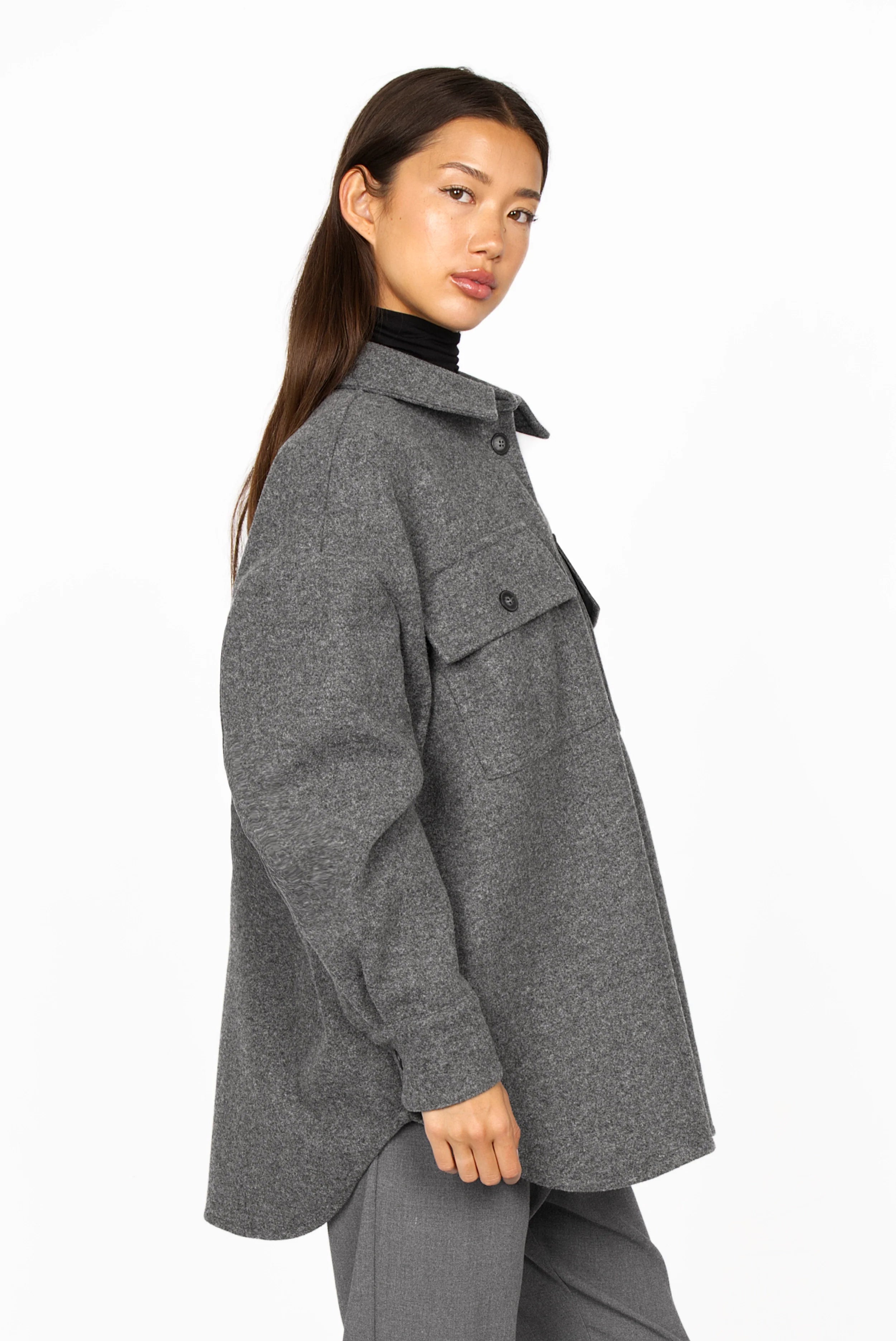 Woman wearing grey BJORA Overshirt made of wool blend with chest pockets and rounded hem.