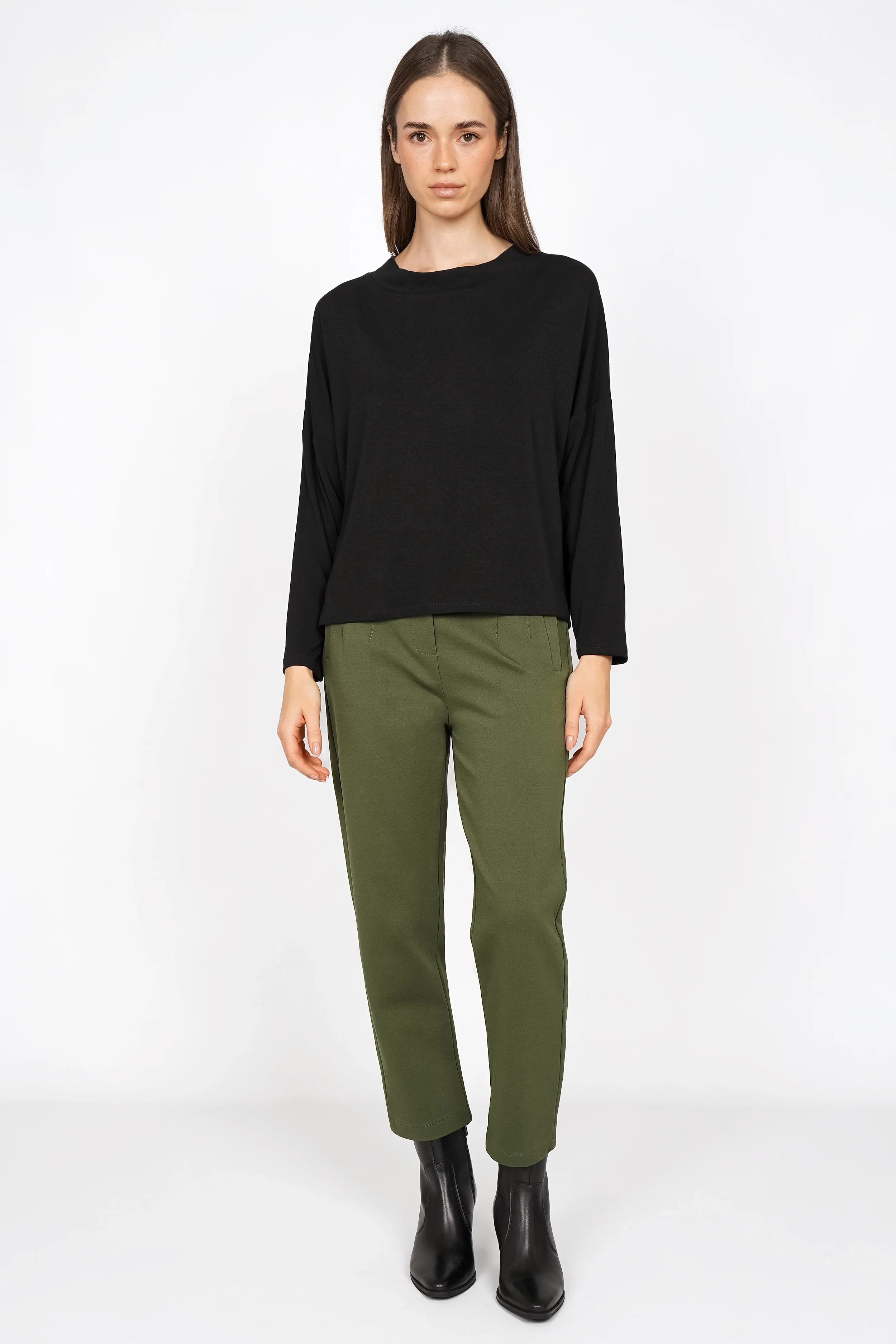 Woman wearing CEELIA olive green ankle pants with elastic waistband and black long sleeve top