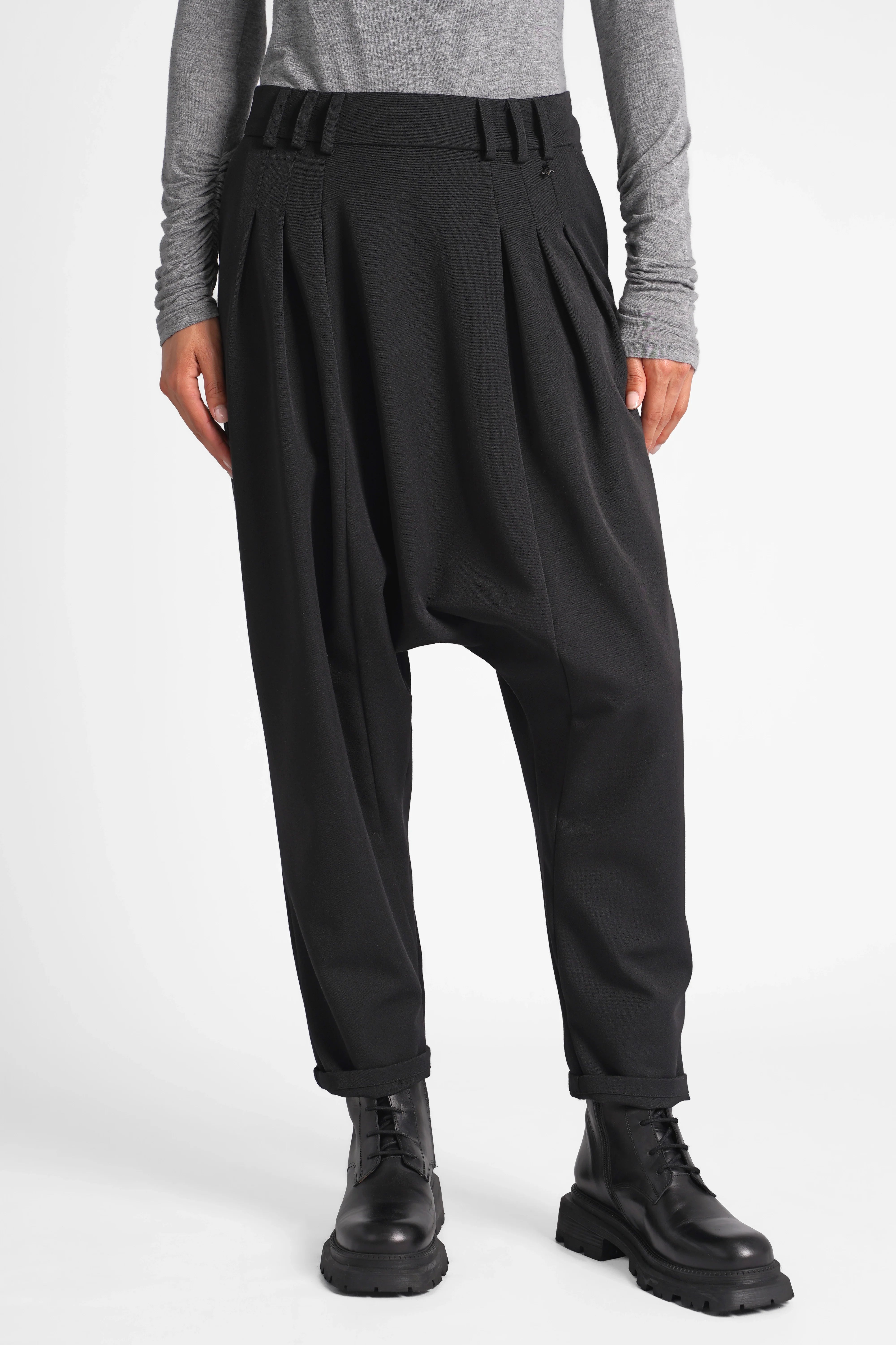 Schwarze DEEP Avantgarde-Hose mit extra tiefem Schritt, Bundfalten und seitlicher Knopfleiste, entspannter Schnitt und soften Tailoring-Stoff.