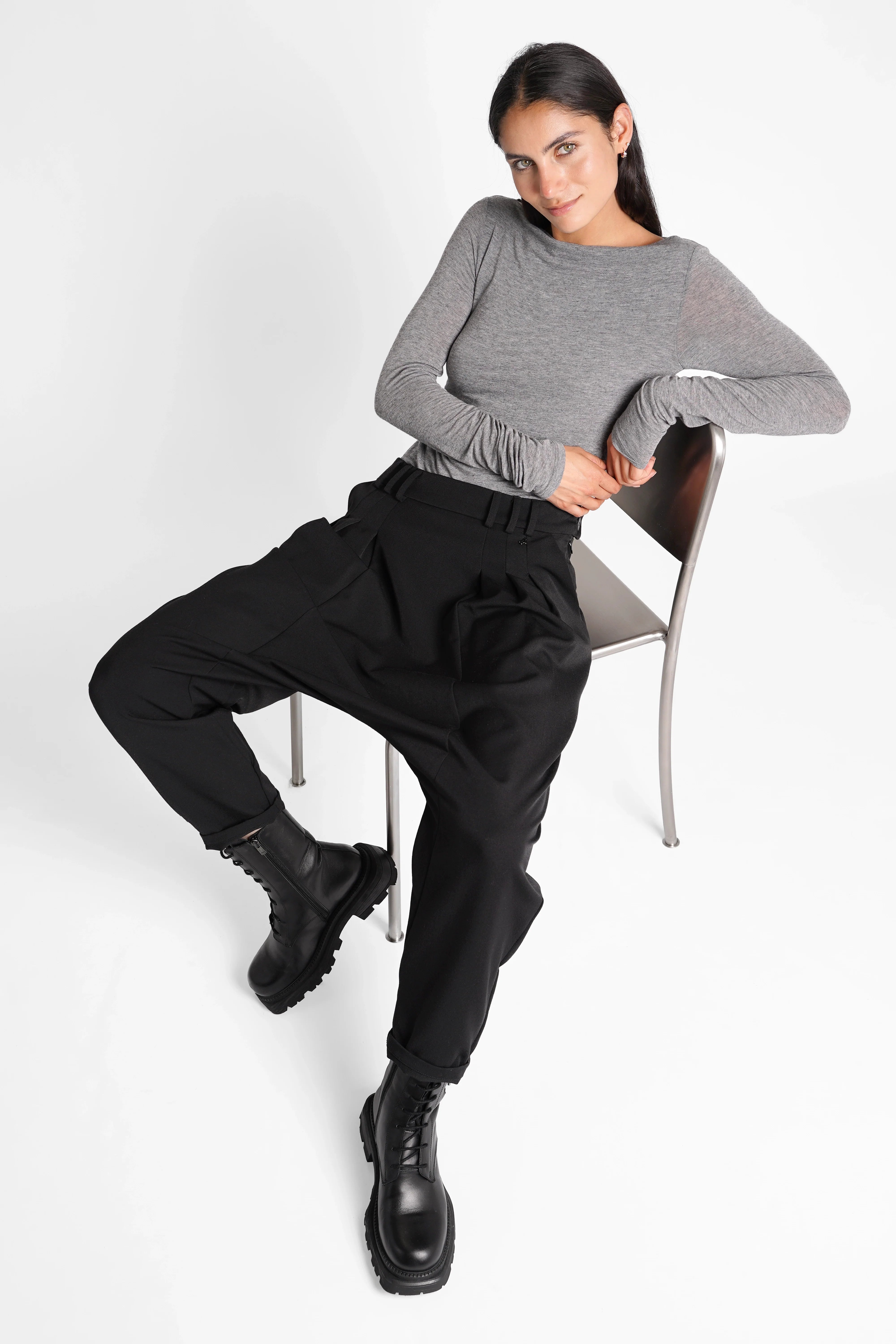 Frau trägt lässige schwarze DEEP Avantgarde-Hose mit tiefem Schritt und seitlichen Knöpfen in relaxed Fit