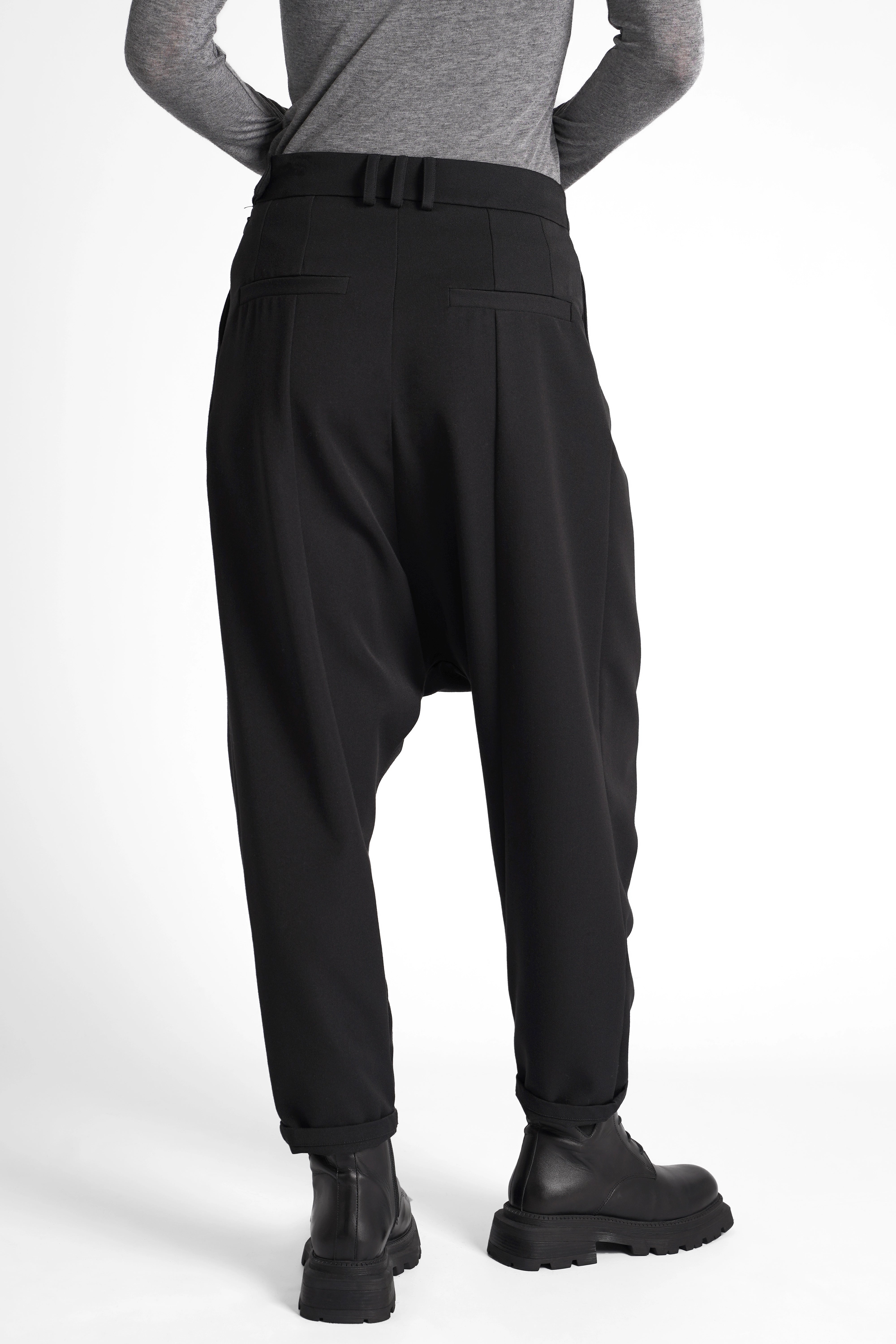 Schwarze DEEP Avantgarde-Hose mit extra tiefem Schritt, Bundfalten und tapered Leg in relaxed Fit, seitliche Knopfschließe und softem Tailoring-Stoffmix