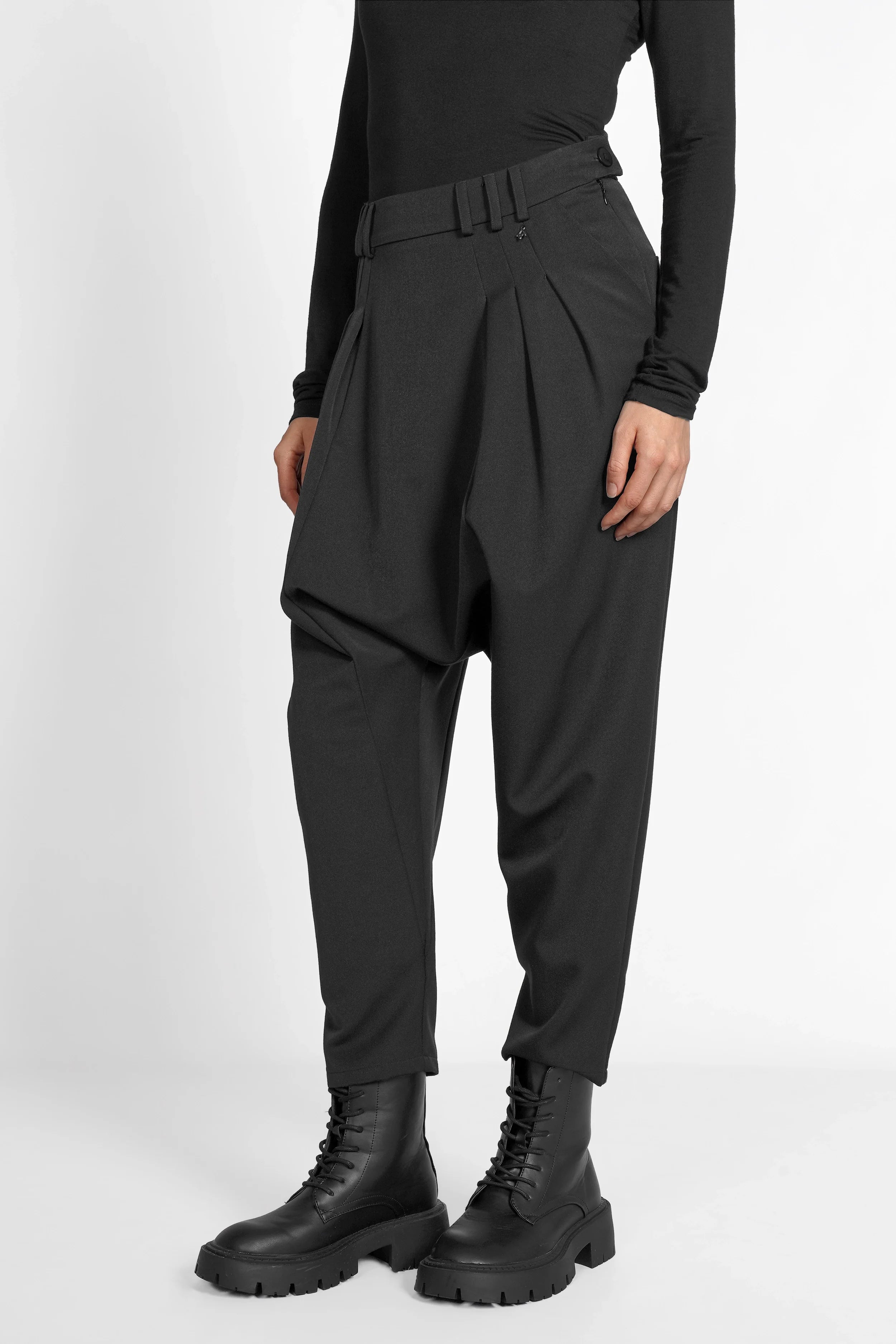 Schwarze DEEP Avantgarde-Hose mit tiefem Schritt, Bundfalten und seitlicher Knopfschließe, tapered Leg und softem Stoff