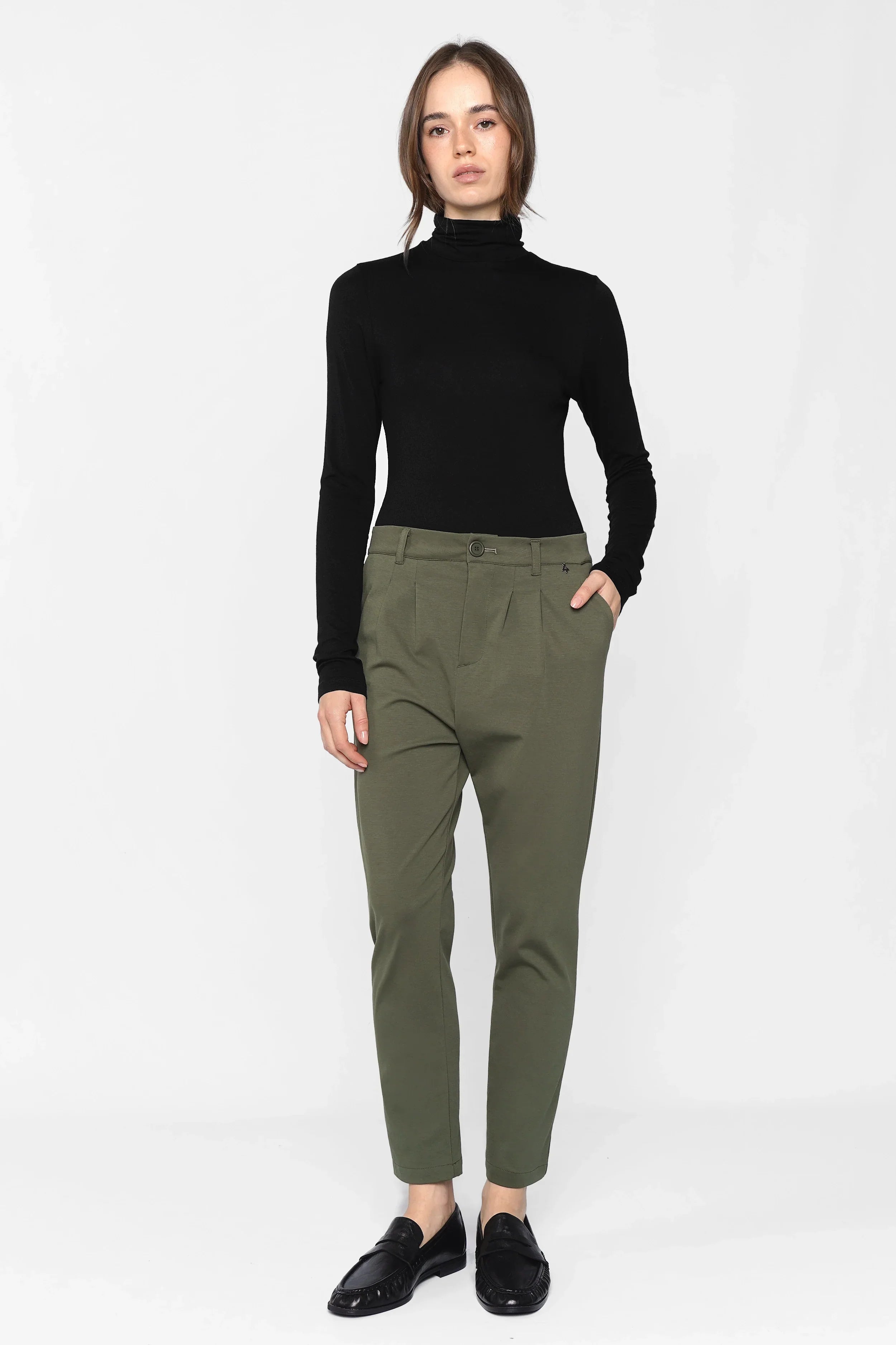 Woman wearing olive green HEELENA Tapered Pants with tapered legs and soft fabric, paired with black long-sleeve top and black shoes