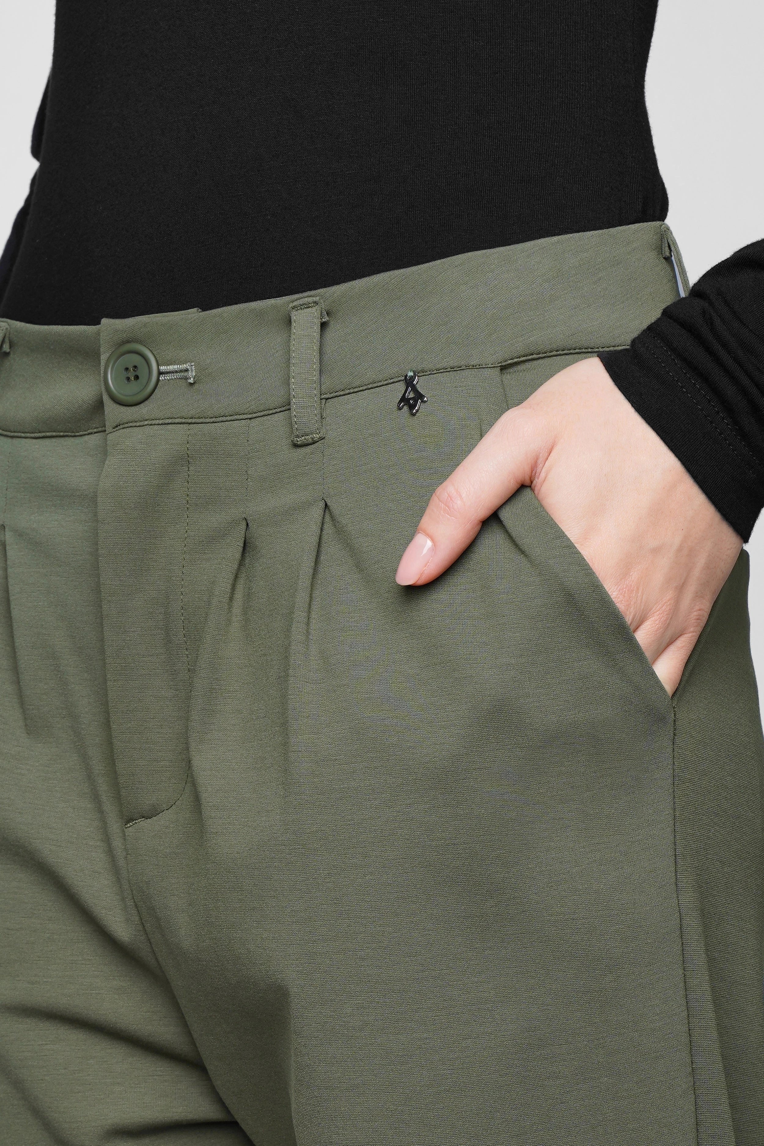 Close-up of olive green HEELENA Tapered Pants with soft fabric, tapered leg, zipper, and button closure.