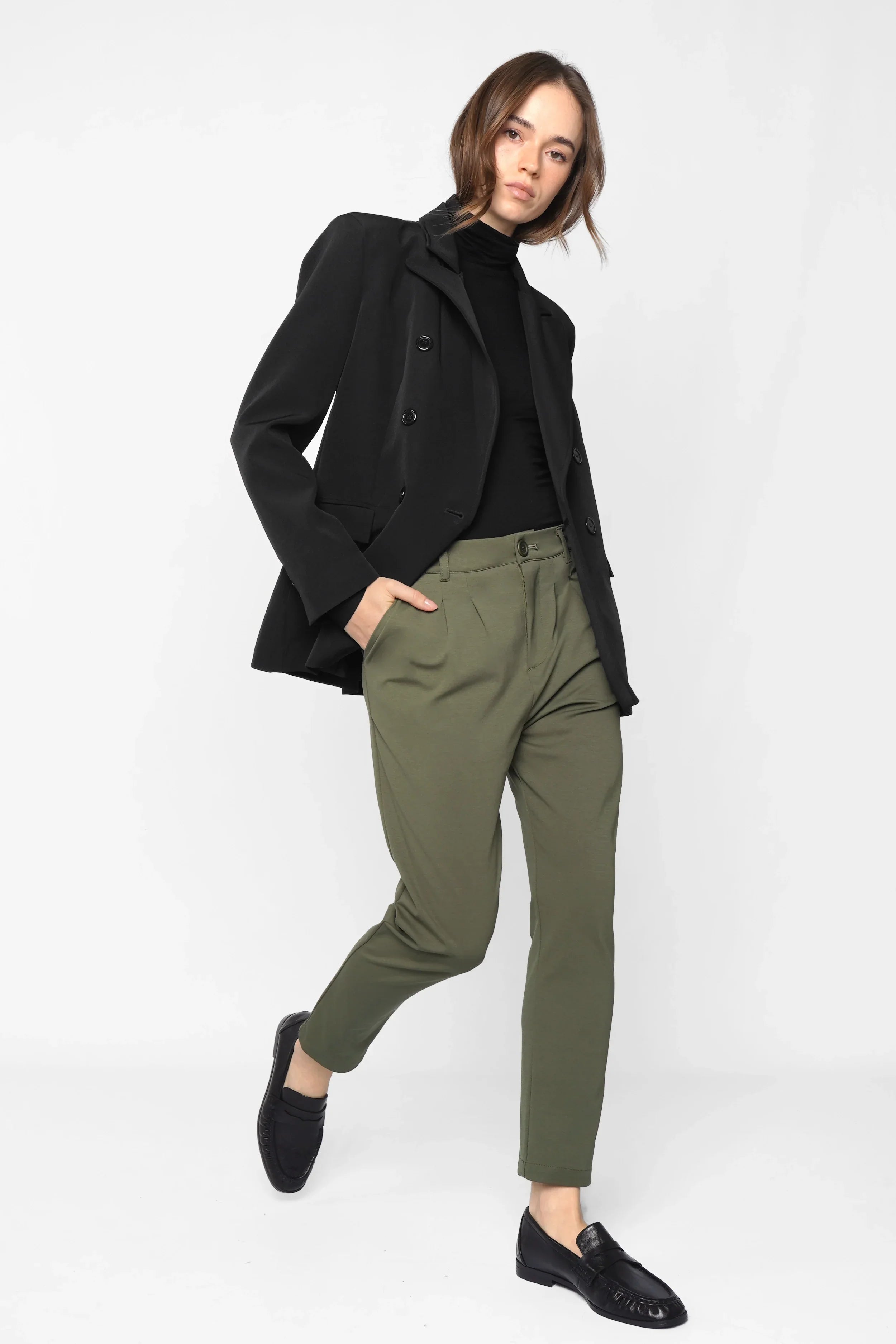 Woman wearing HEELENA Tapered Pants in olive green with black blazer and loafers