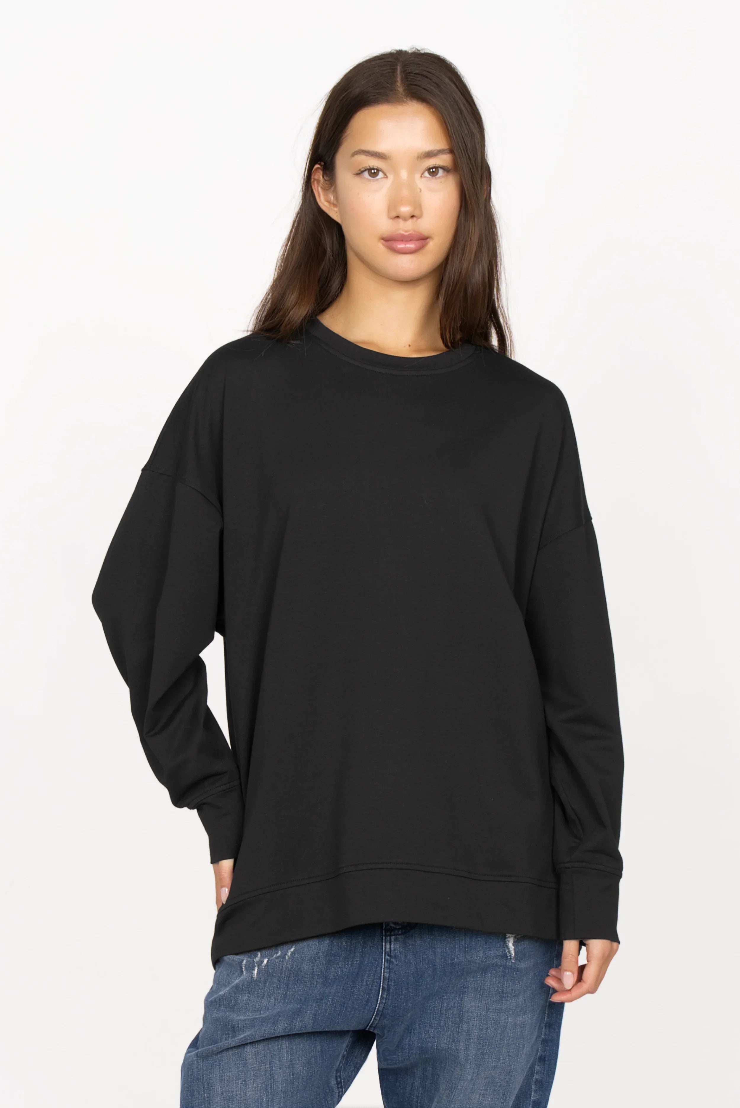 Black oversized sweater with round neckline and dropped shoulders worn by female model