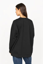 Black EIREL oversize sweater with relaxed fit, dropped shoulders, and tonal logo embroidery.