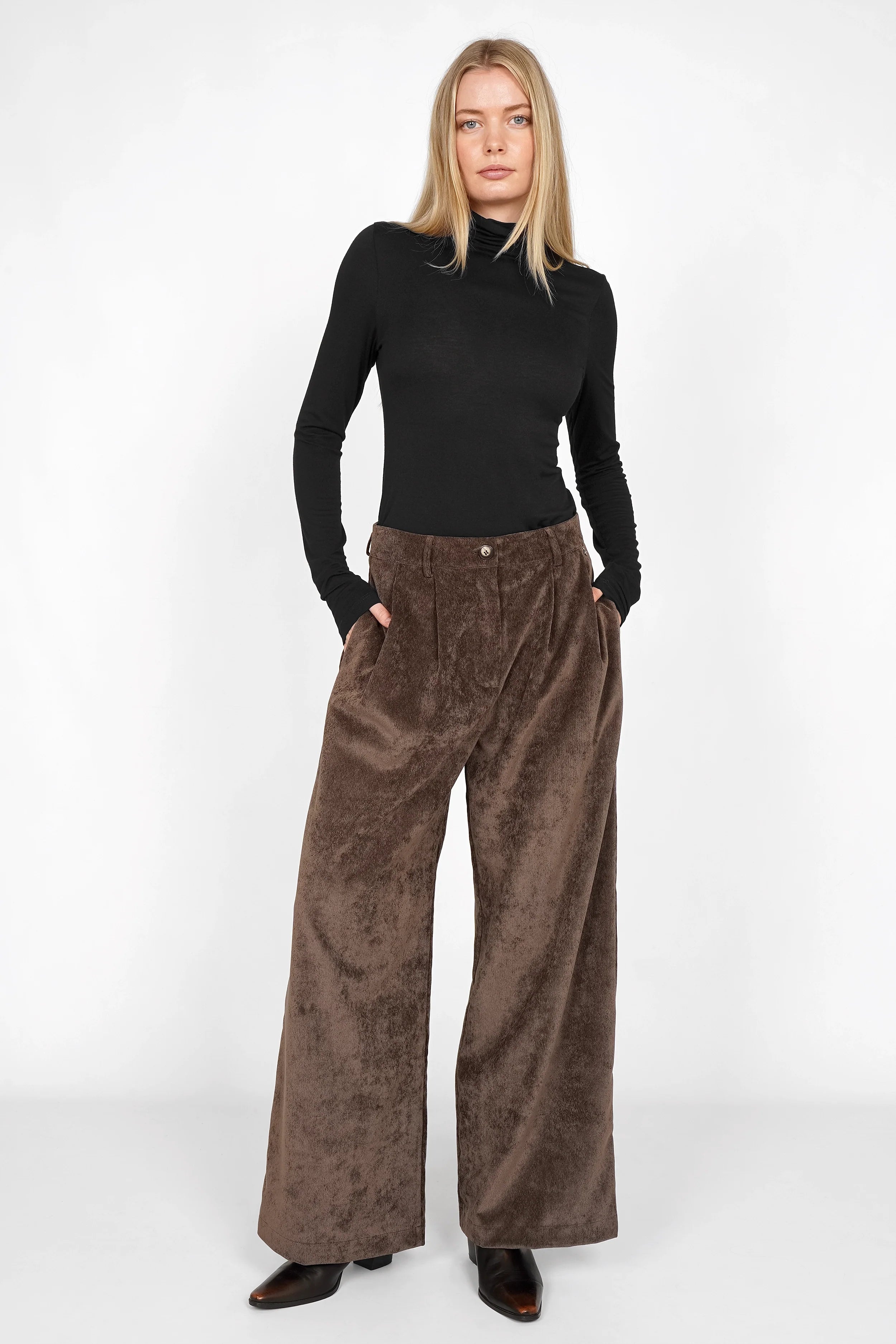 Frau trägt ELEE Wide Leg Cordhose in braun mit hohem Bund und weiten Beinen aus weichem Cordstoff.