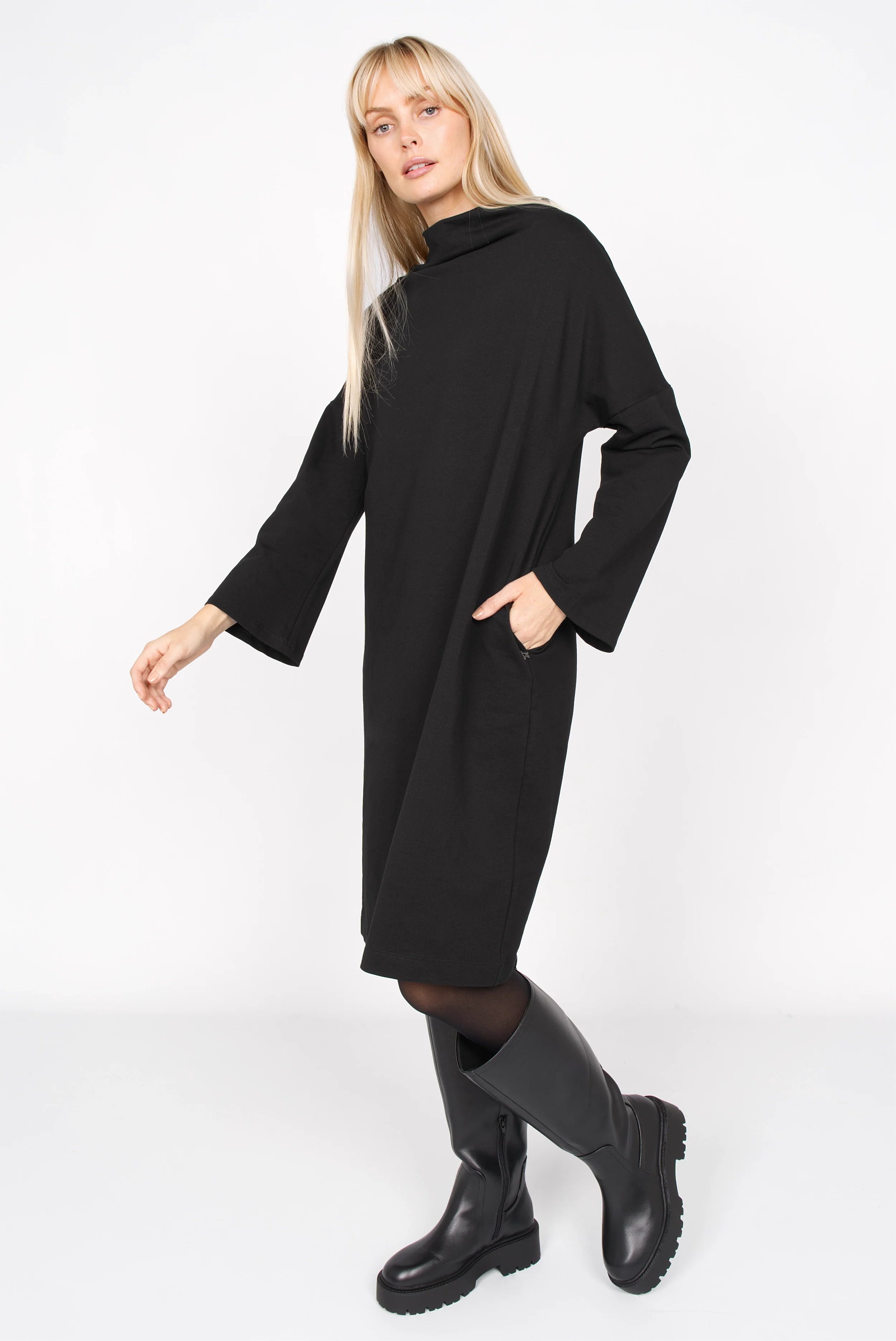Schwarzes Sweatkleid mit Hochkragen, überschnittenen Schultern und trapezförmigen Ärmeln, locker geschnitten mit Seitentaschen.