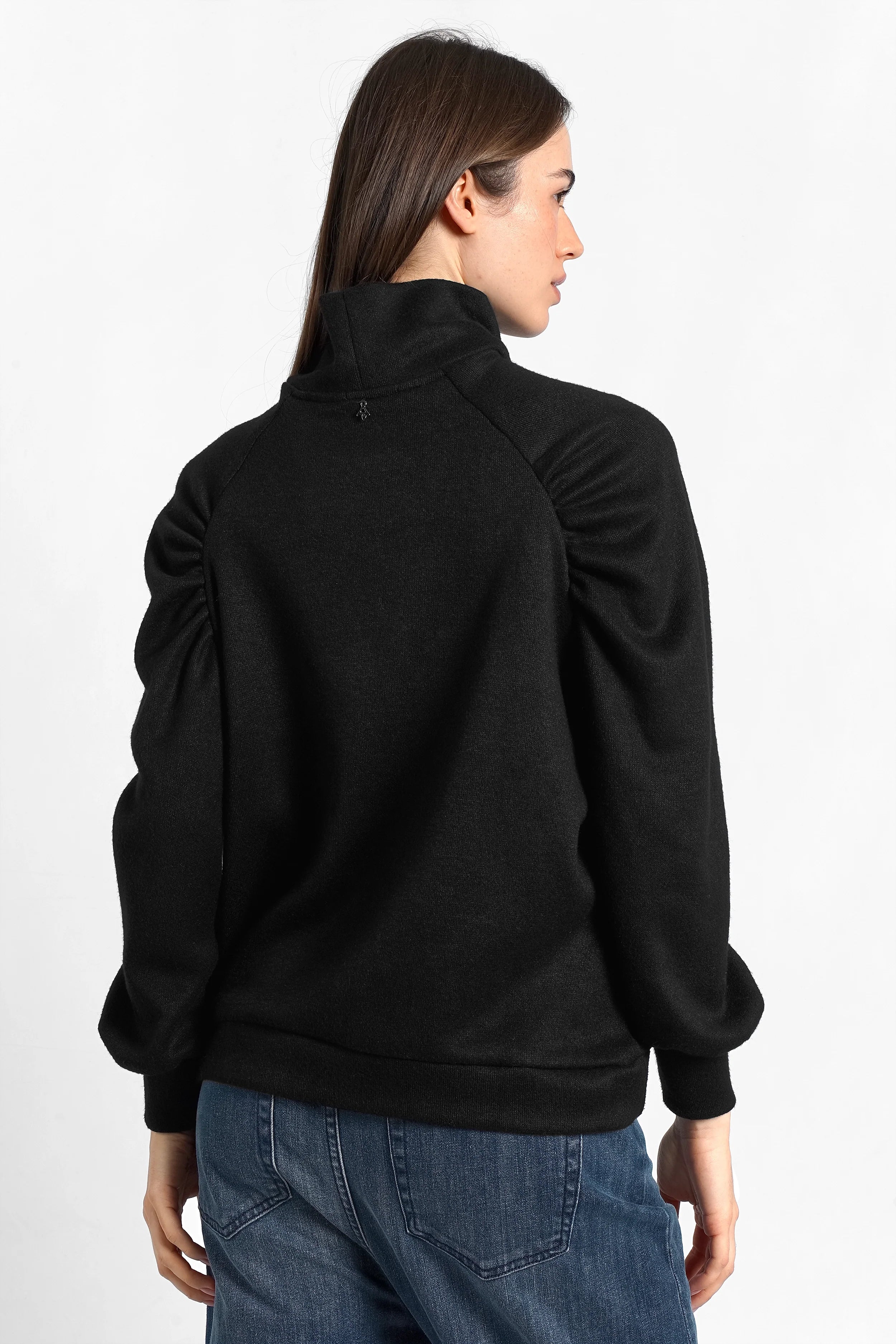 Schwarzes Oberteil aus softem Feinstrick mit Stehkragen und Raglanärmeln bei Frau von hinten getragen