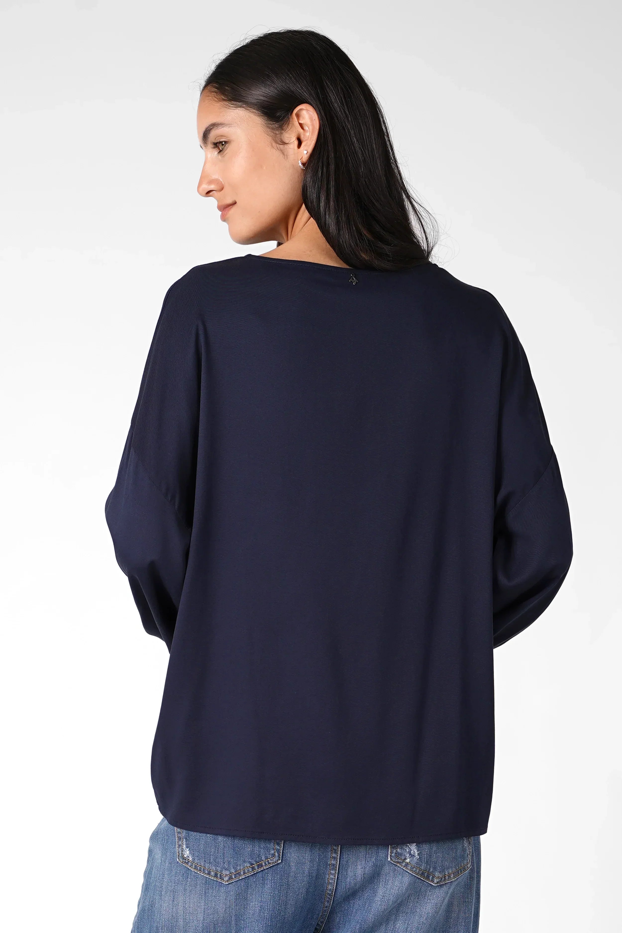 Frau trägt locker geschnittene Greta.K Bluse aus feiner Twill Viskose mit Rundhalsausschnitt und überschnittenen Schultern