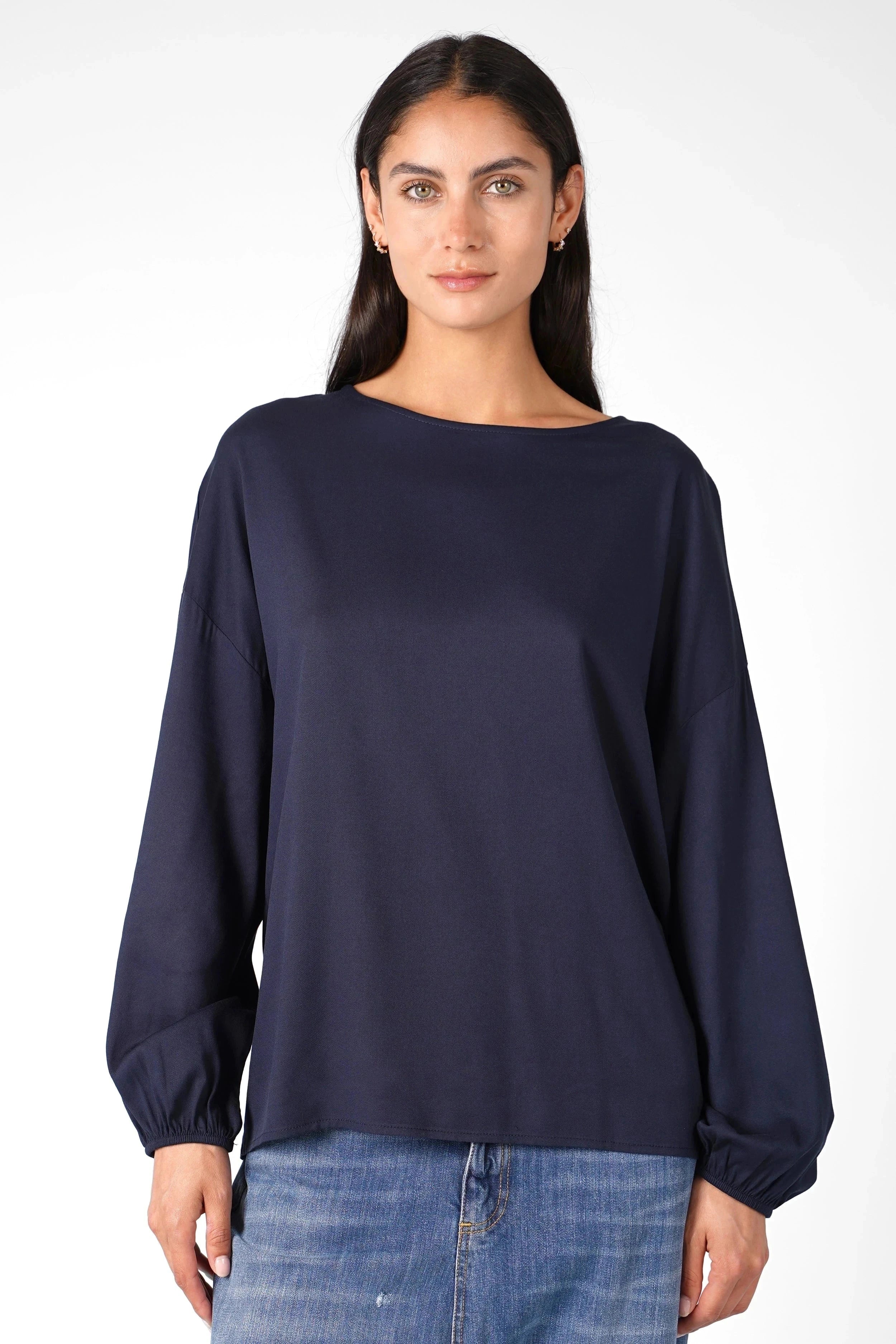 Frau trägt dunkelblaue Greta.K Bluse mit Rundhalsausschnitt und langen Ärmeln aus weicher Twill Viskose