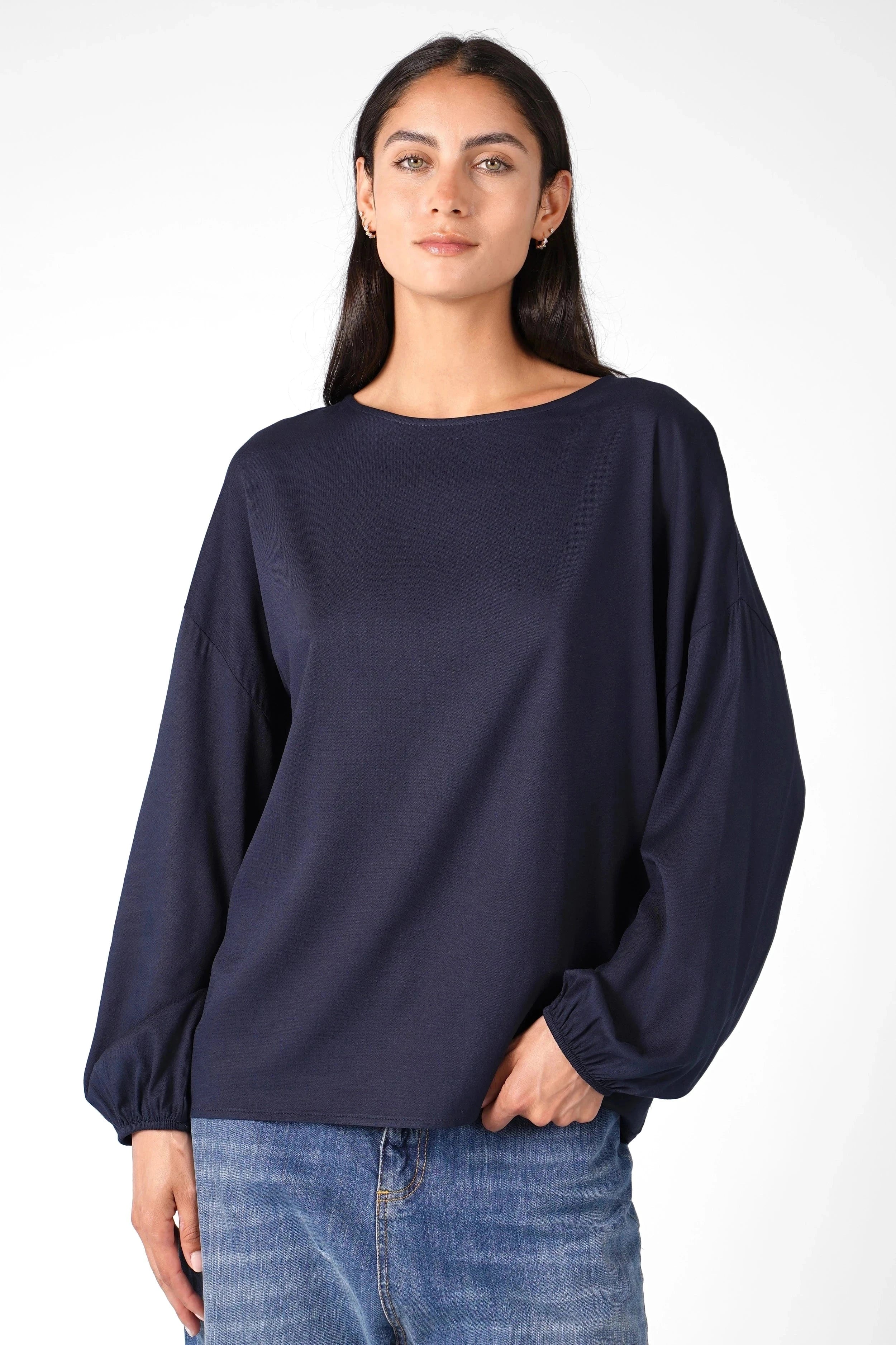 Frau trägt locker geschnittene Greta.K Bluse aus feiner Twill Viskose mit Rundhalsausschnitt und elastischen Ärmeln