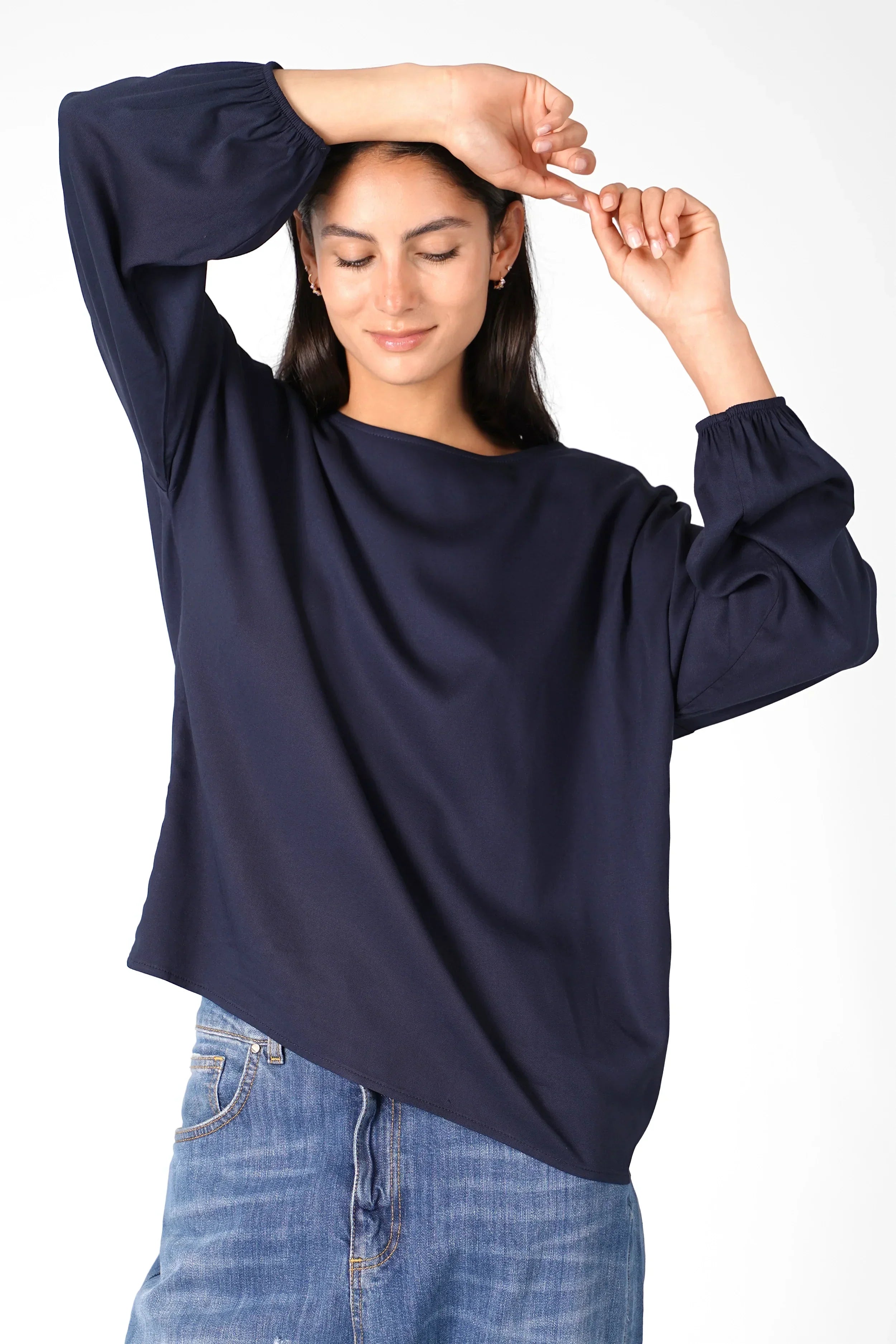 Frau trägt locker geschnittene Greta.K Bluse aus Twill Viskose mit Rundhalsausschnitt und langen Ärmeln mit elastischen Abschlüssen