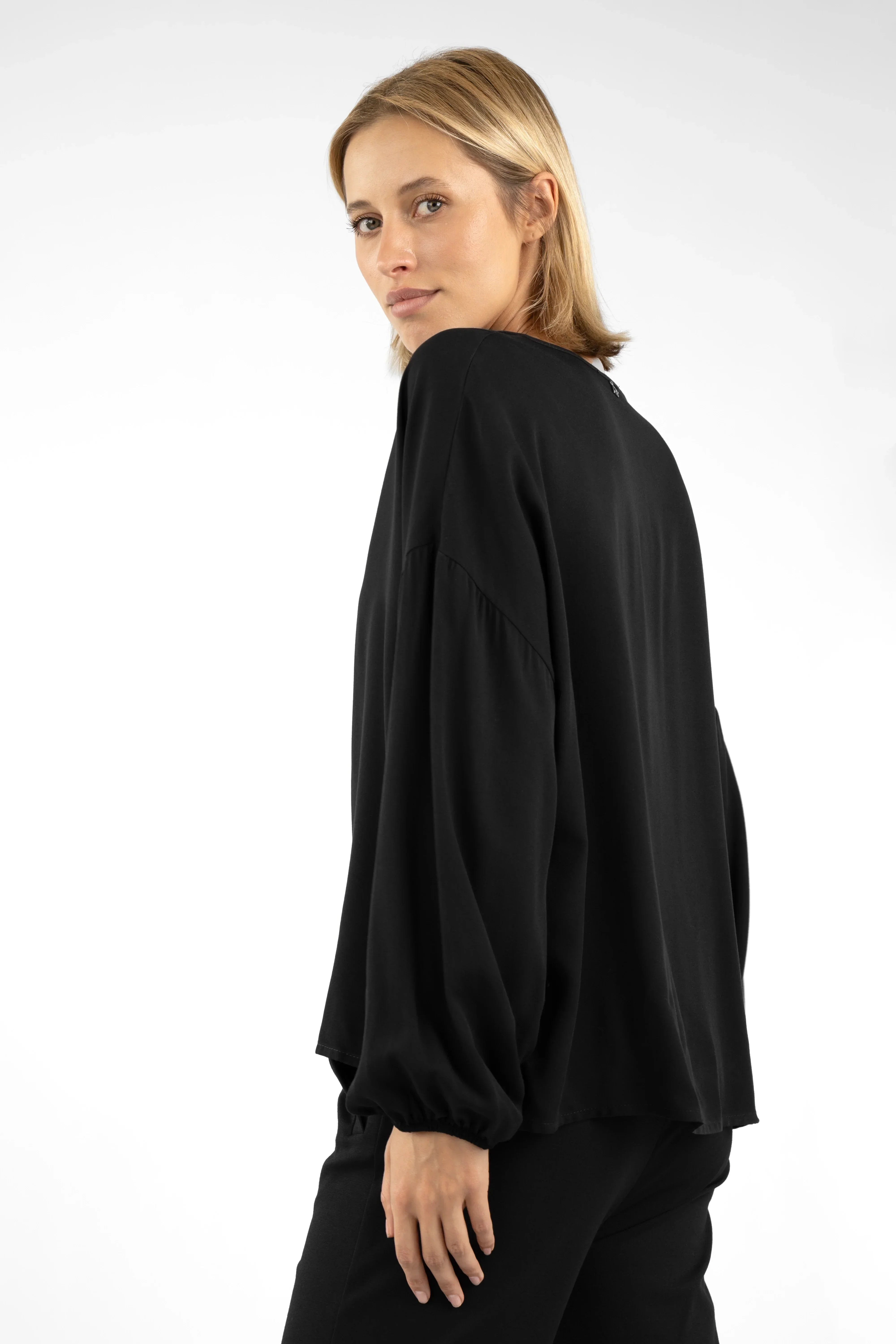 Frau trägt schwarze GRETA.K V-Neck Bluse aus weicher Twill Viskose mit lockerem Sitz und langen Ärmeln