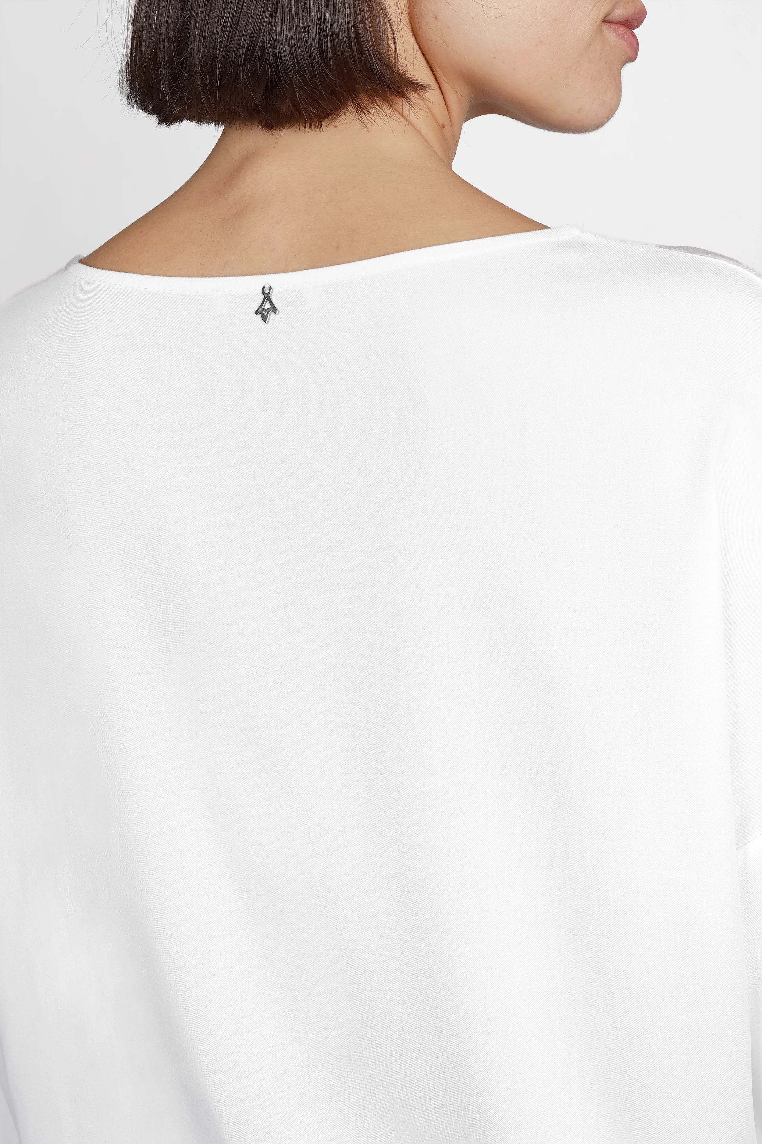 Rückansicht der weißen GRETA.K Bluse mit Rundhalsausschnitt und überschnittenen Schultern aus weicher Twill Viskose