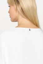 Frau trägt weiße GRETA.K Bluse mit Rundhalsausschnitt und überschnittenen Schultern aus weicher Twill Viskose