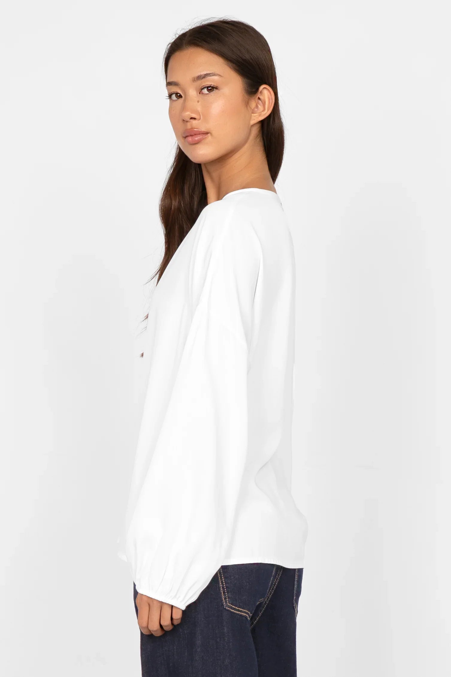 Frau trägt zeitlose GRETA.K V-Neck Bluse aus leichter Viskose mit Ballonärmeln in Weiß