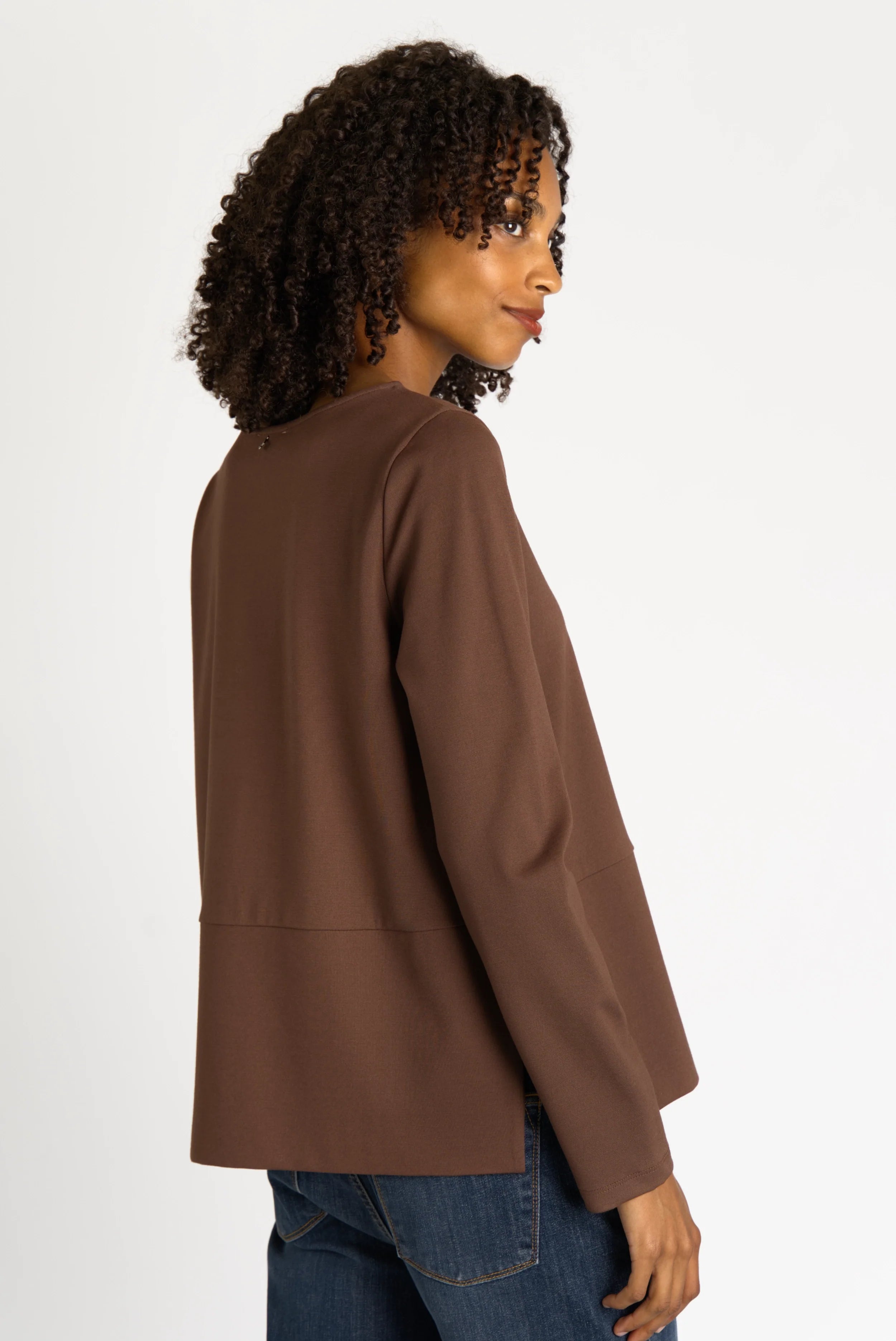 Woman wearing brown HAEIN Clean Jersey long sleeve top with U-boat neckline and side slits viewed from side
