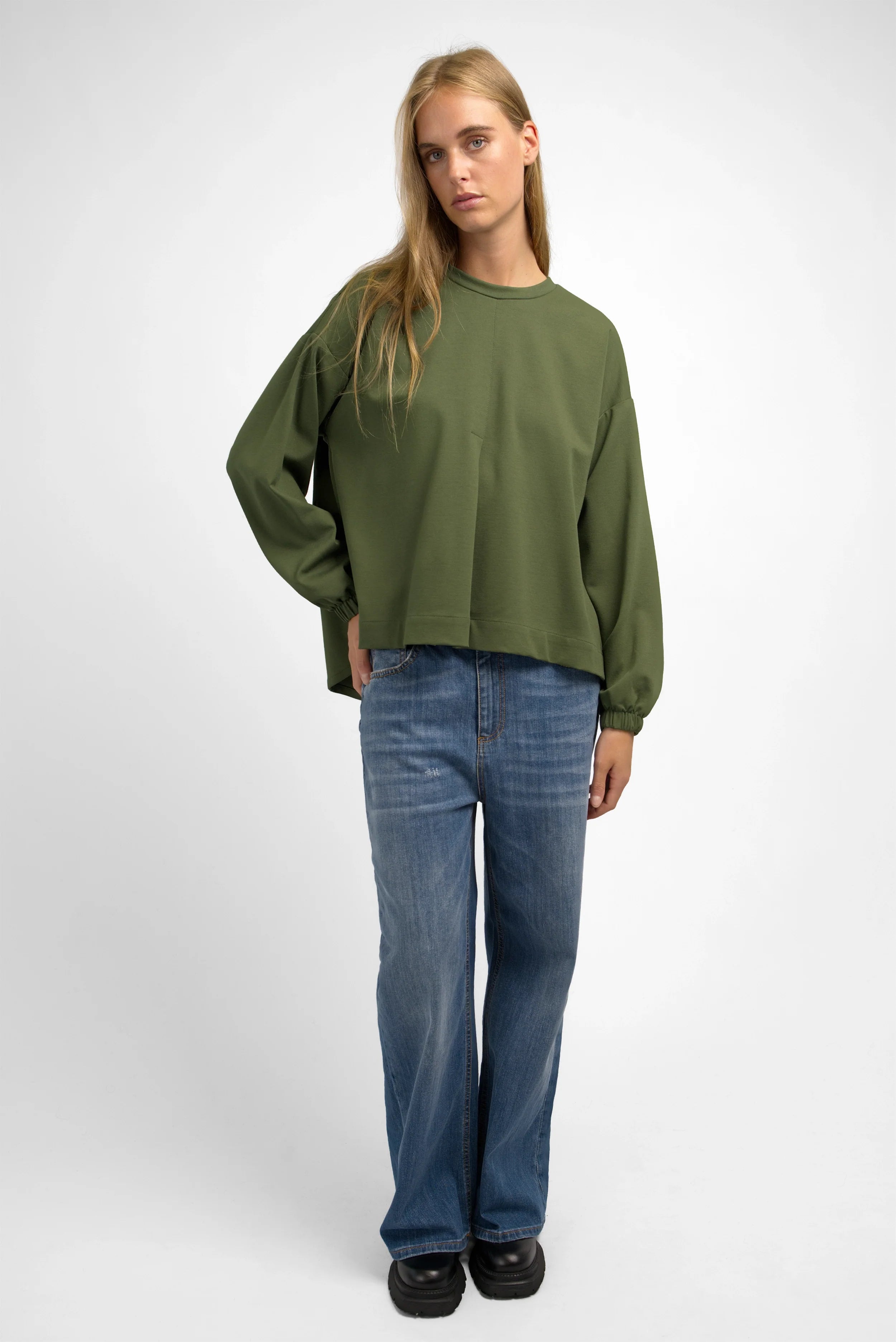 Damen trägt grünes HAGLA Shirt aus schwerem Viskose-Mix mit Rundhalsausschnitt und elastischen Ärmelbündchen im Relaxed Fit