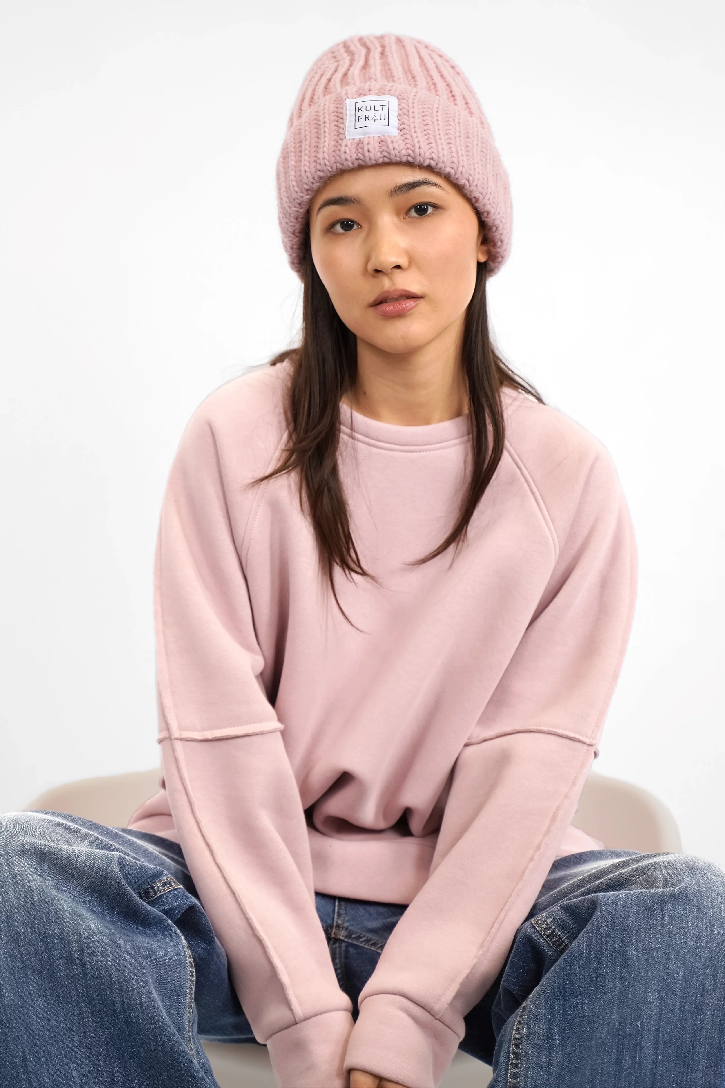 Frau trägt pinke HATY Strickmütze aus grobem Rippstrick mit breitem Umschlag und Kultfrau-Logo
