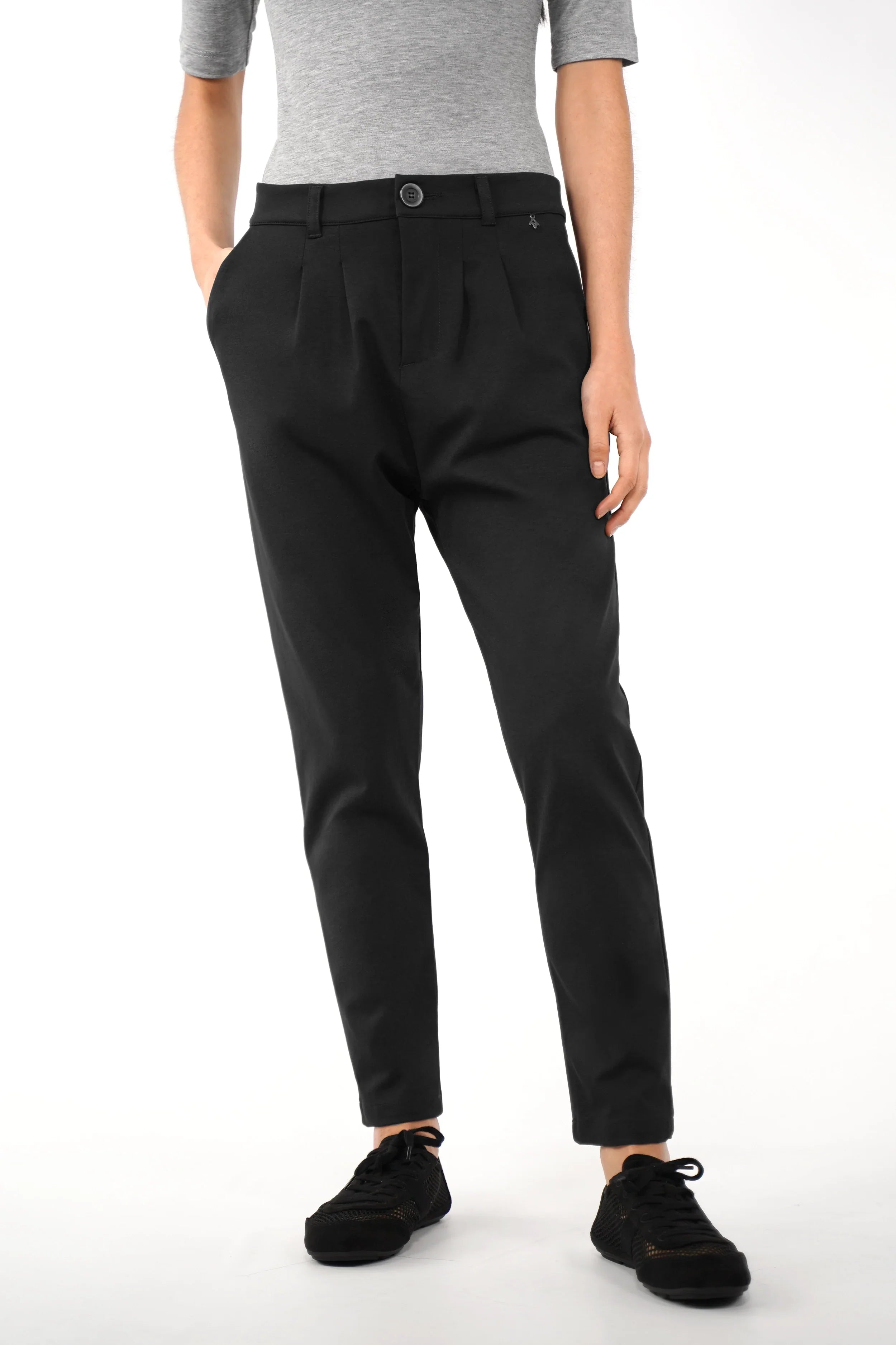 Black HEELENA tapered pants with soft fabric and slim leg fit modeled with grey top and black sneakers