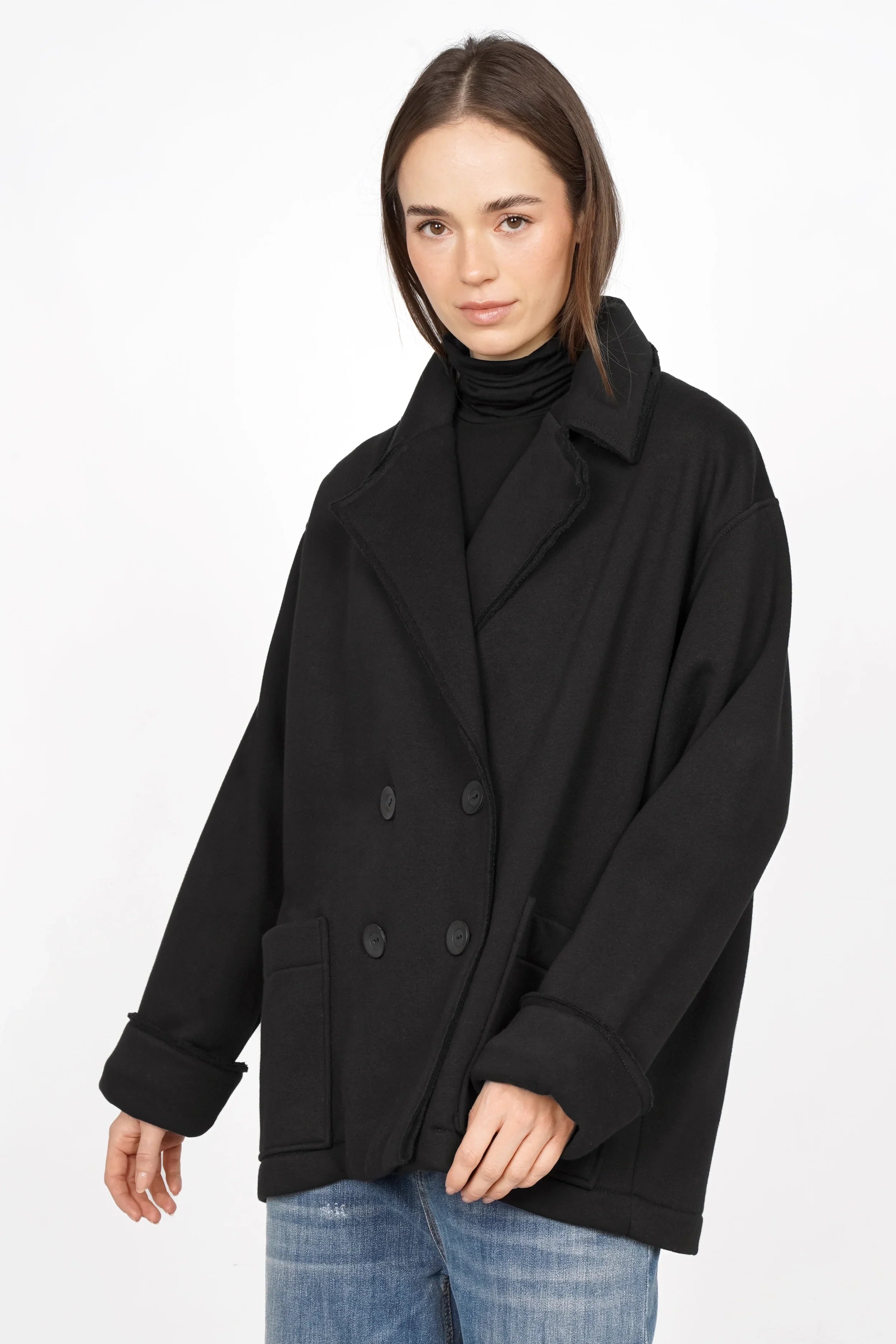 Female model wearing black HELIEE Oversized Sweat-Kurzmantel with double-breasted buttons and large patch pockets