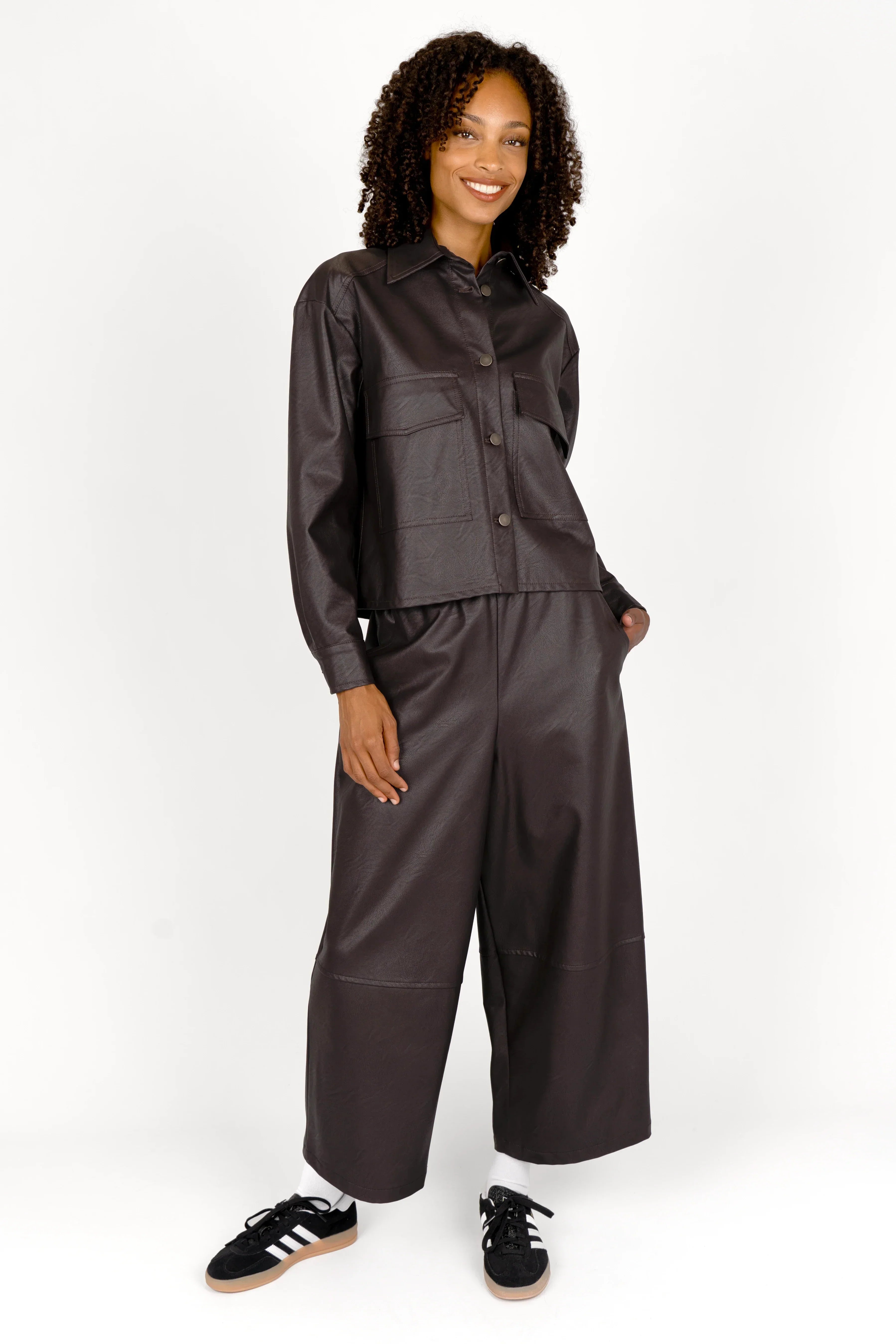 Frau trägt HERA Wide-Leg Hose aus schwarzem Eco-Leder mit elastischem Bund und weitem Bein