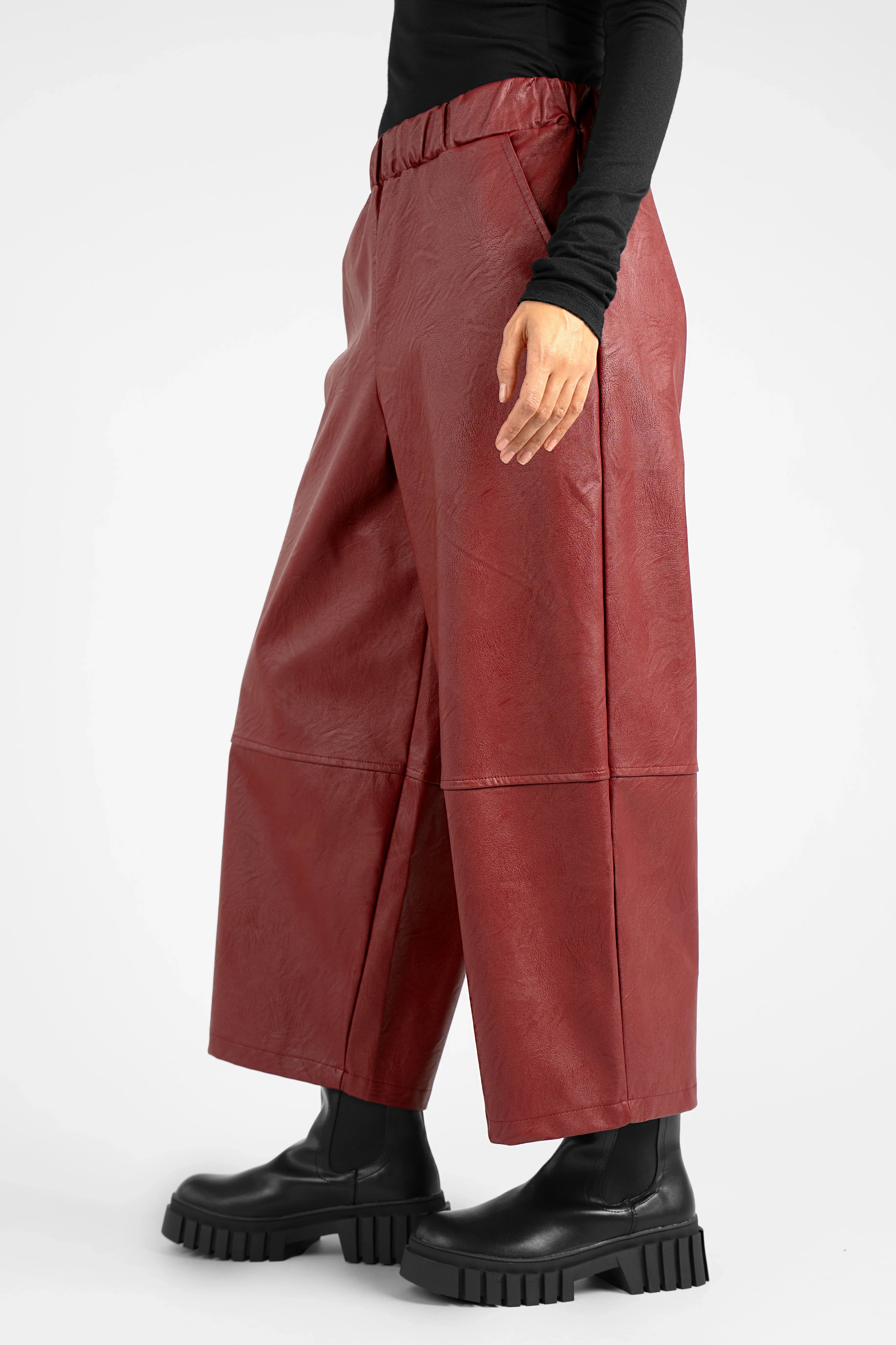 HERA Wide Leg Hose in soft eco-leather with elastic waistband, side pockets, knee seams, and relaxed fit in burgundy color.