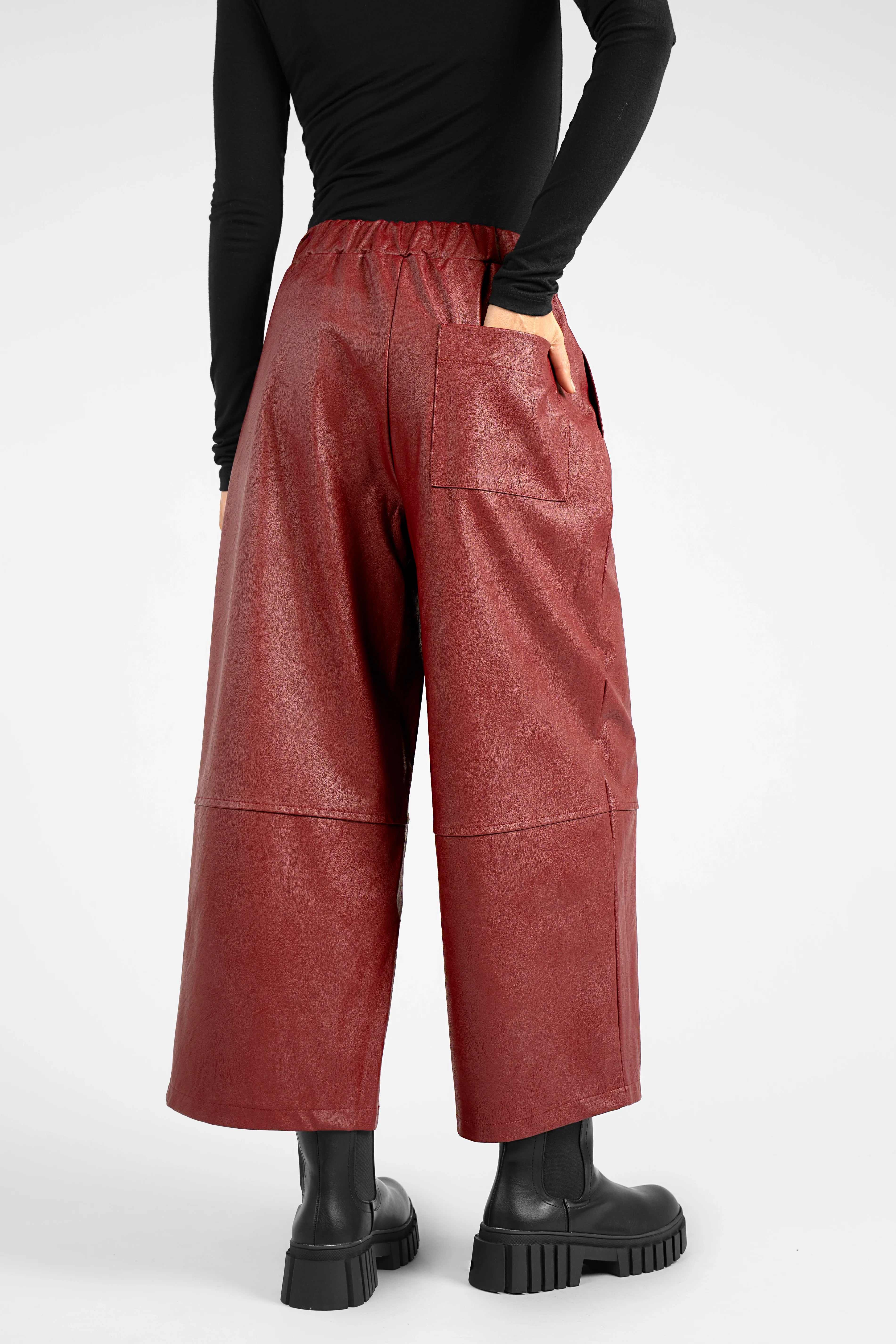 Back view of model wearing red HERA Wide Leg Hose made of soft eco-leather with elastic waistband and relaxed fit