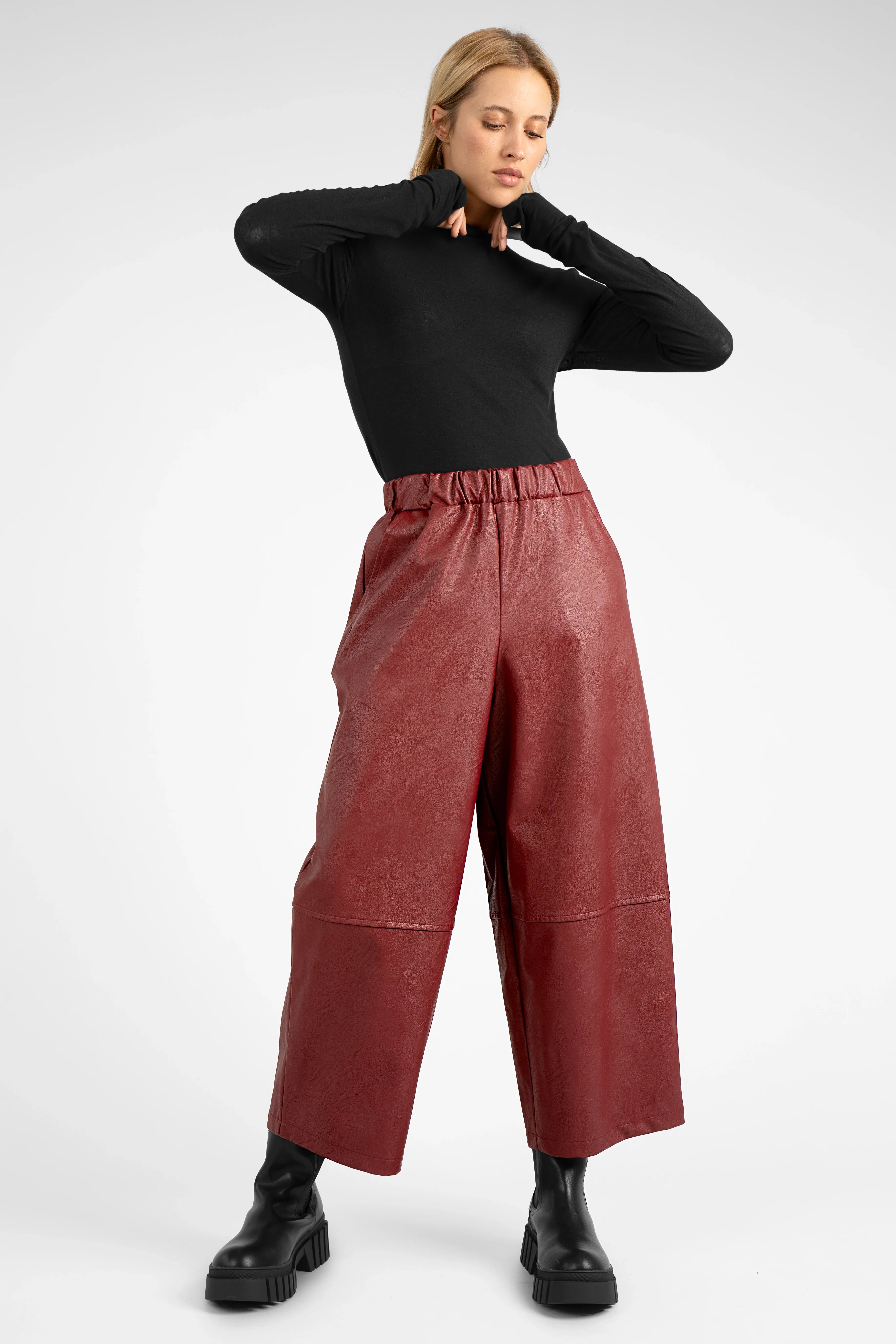 Woman wearing red HERA wide leg hose in soft eco-leather with elastic waistband and relaxed fit