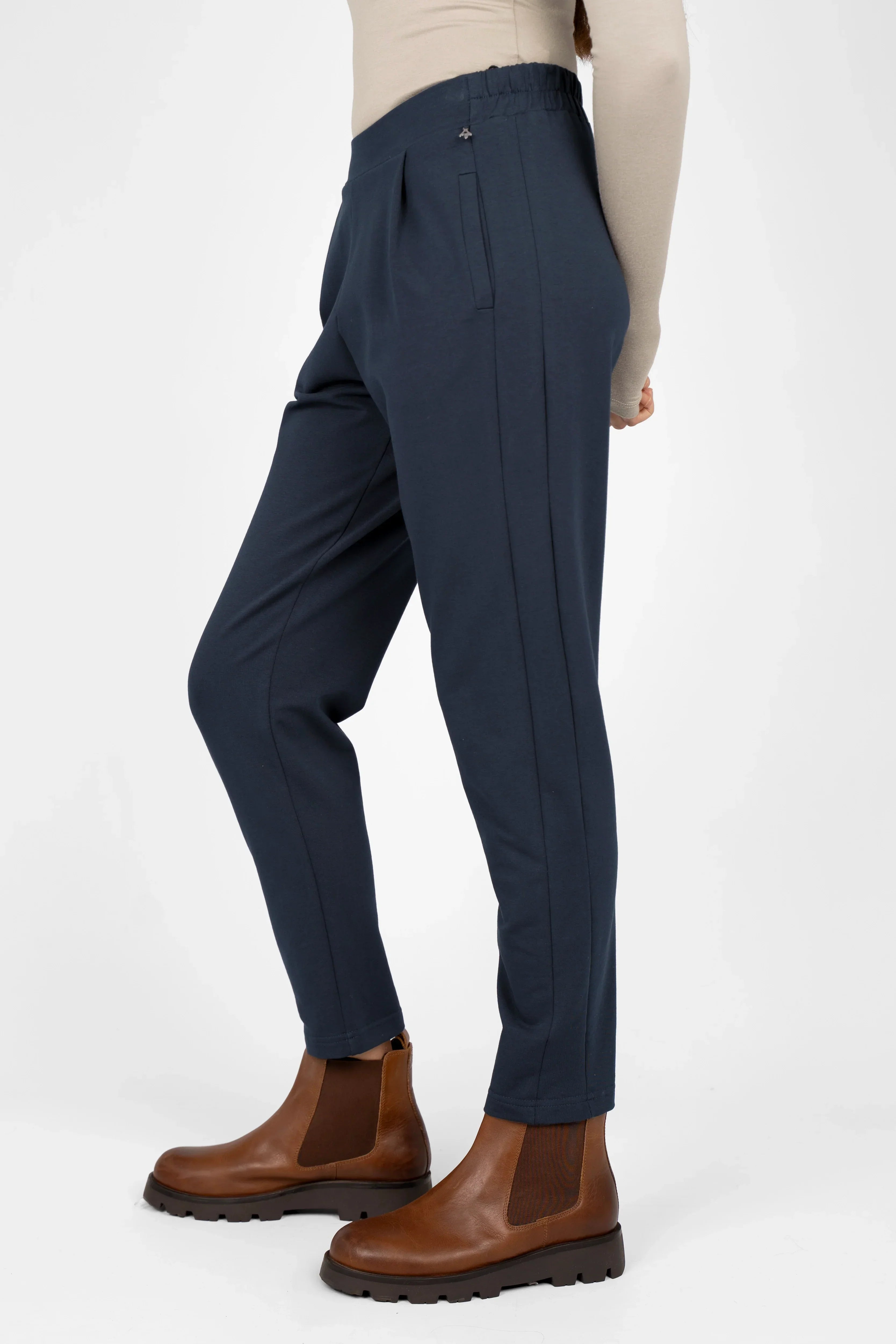 Damen HILLA.K Jerseyhose mit mittelhohem Bund, leichter Tapered Passform und elastischem Baumwollstretch in Dunkelblau, kombiniert mit braunen Chelsea Boots.